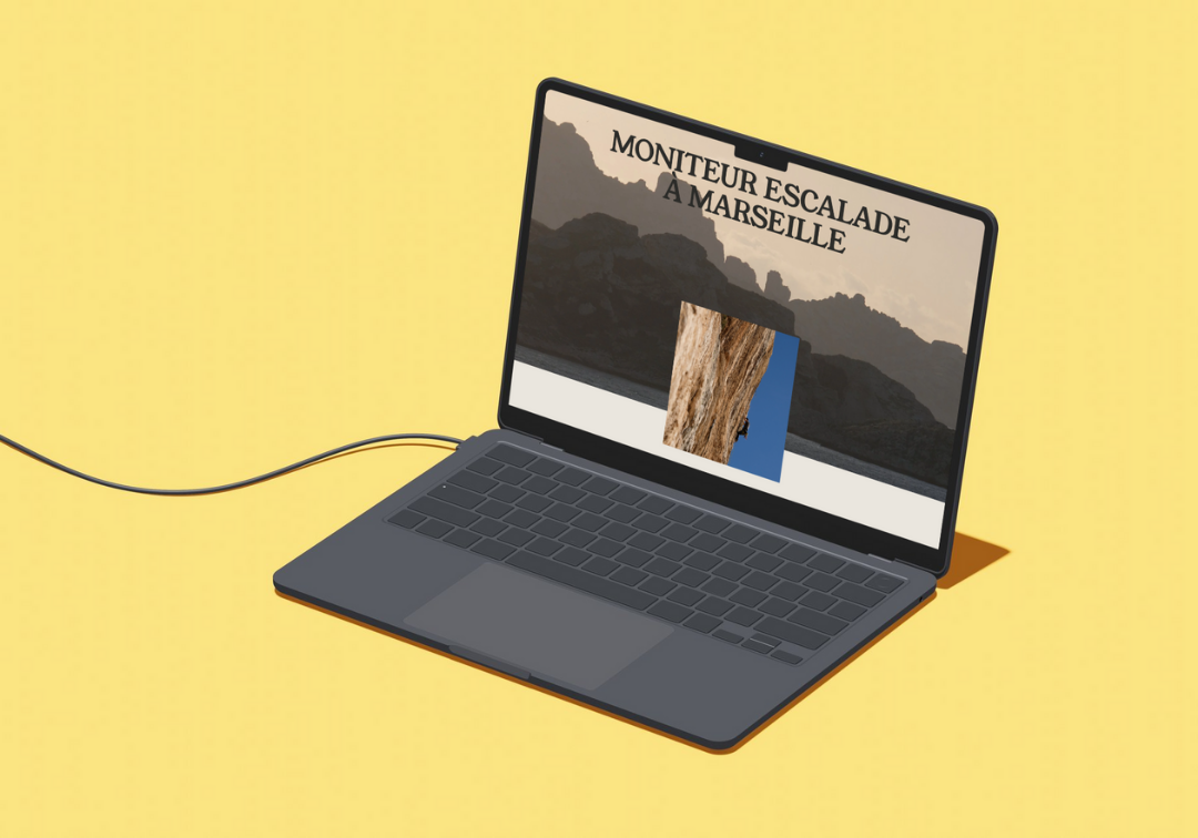 Un ordinateur portable noir affichant une page web avec le texte "Monteure escalade à Marseille" sur un fond jaune.