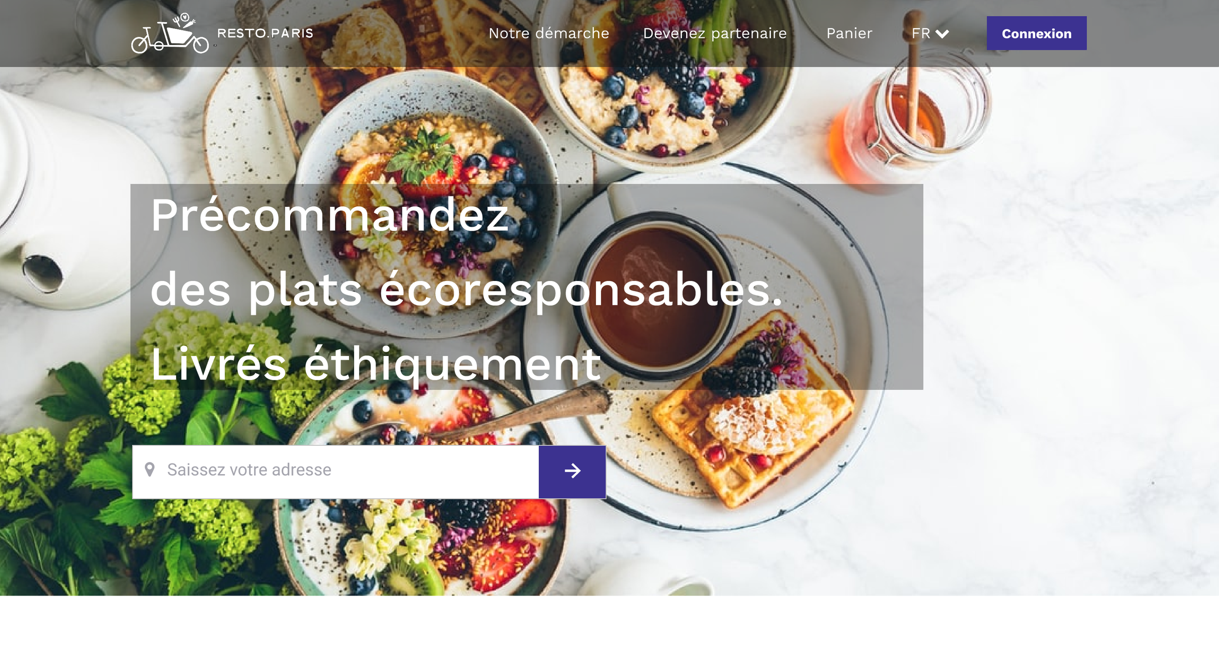 Petits-déjeuners avec fruits frais, yaourt, pain grillé, et thé ou café sur une table blanche, avec des fleurs vertes en premier plan.