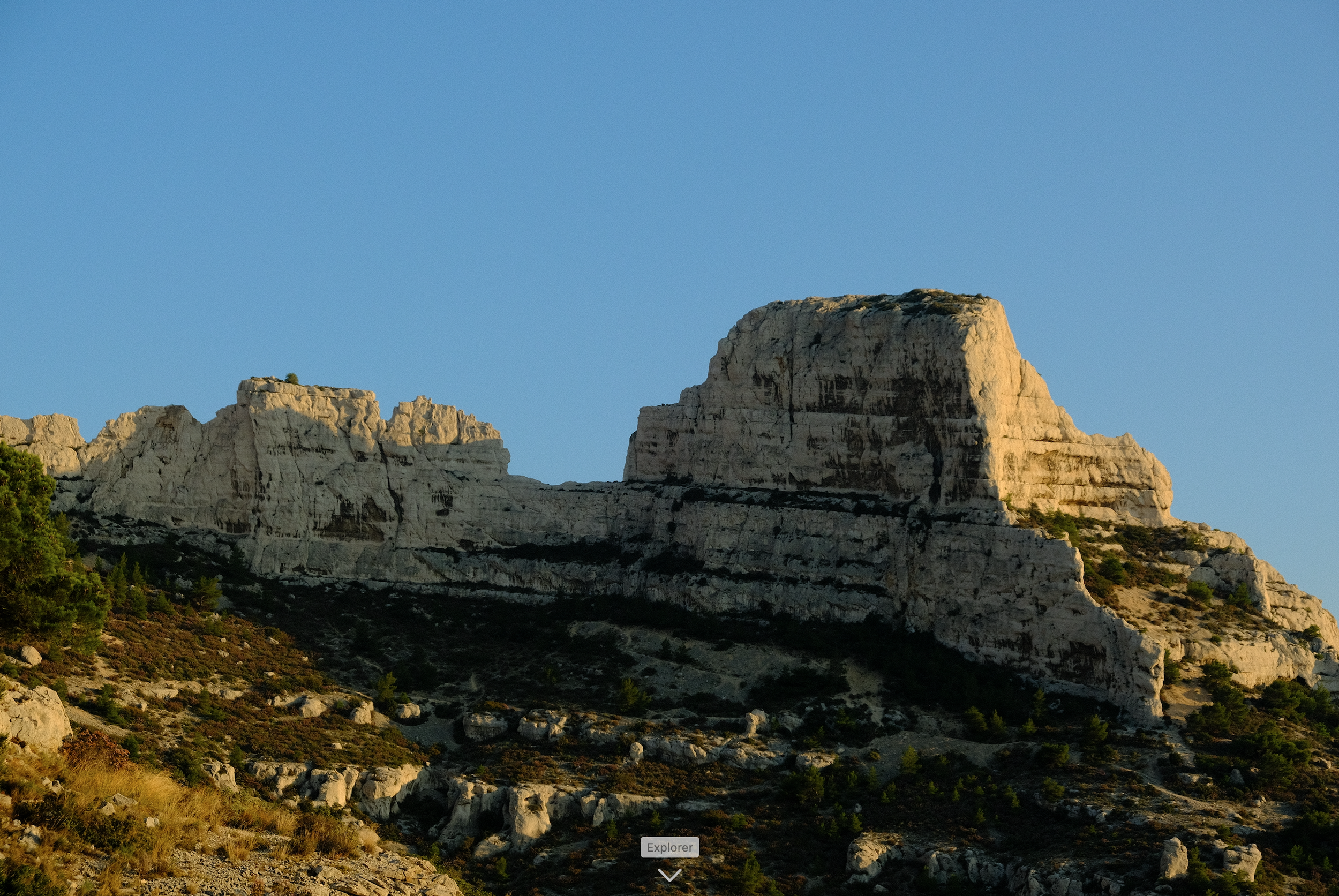 Montagne rocheuse dans les calanques de Marseille avec peu d'arbres sous un ciel clair