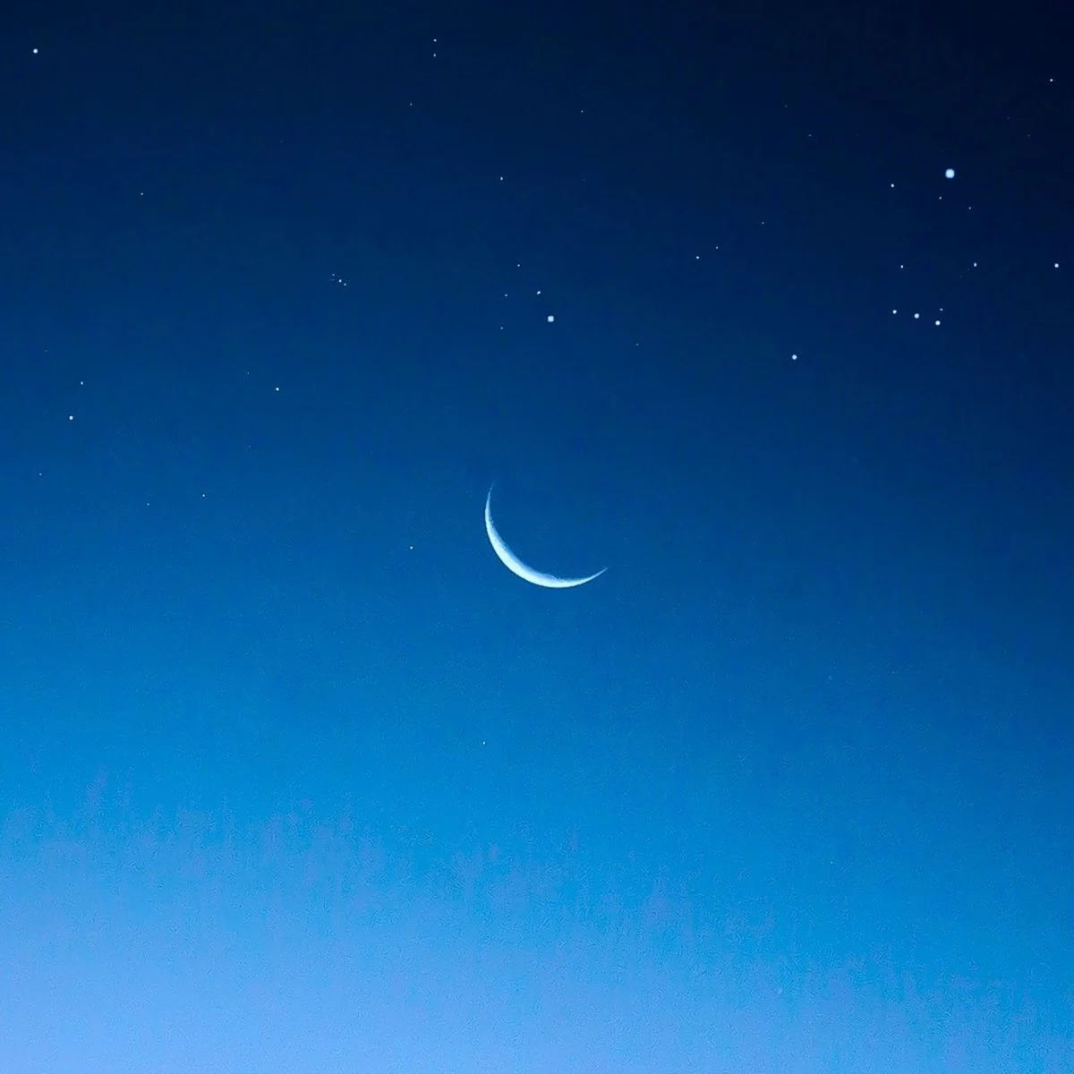 Night sky with a crescent moon and stars.