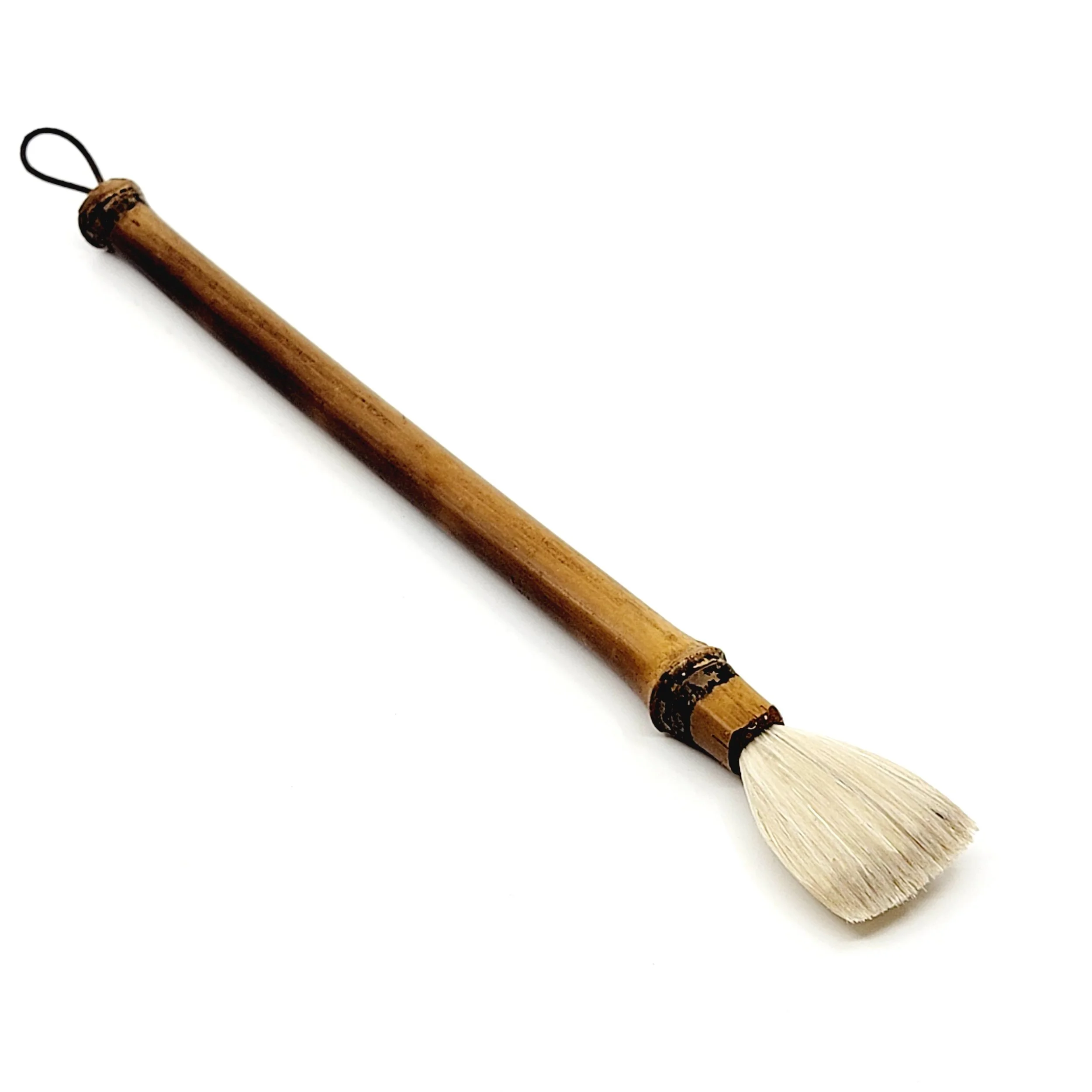 A traditional calligraphy brush with a wooden handle and white bristles against a white background.