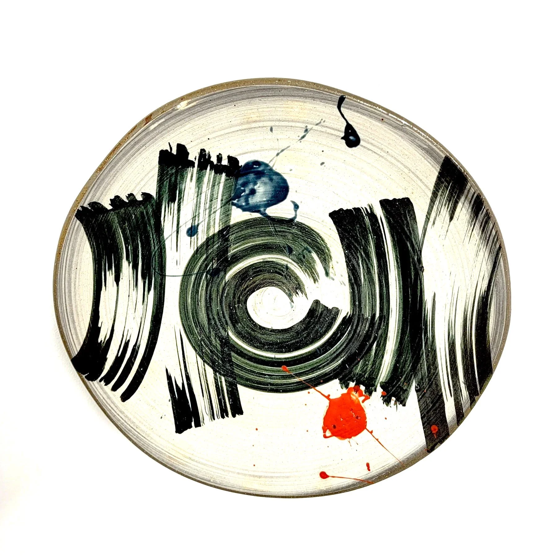 A metal can with black barcode lines and blue and red paint splatters.