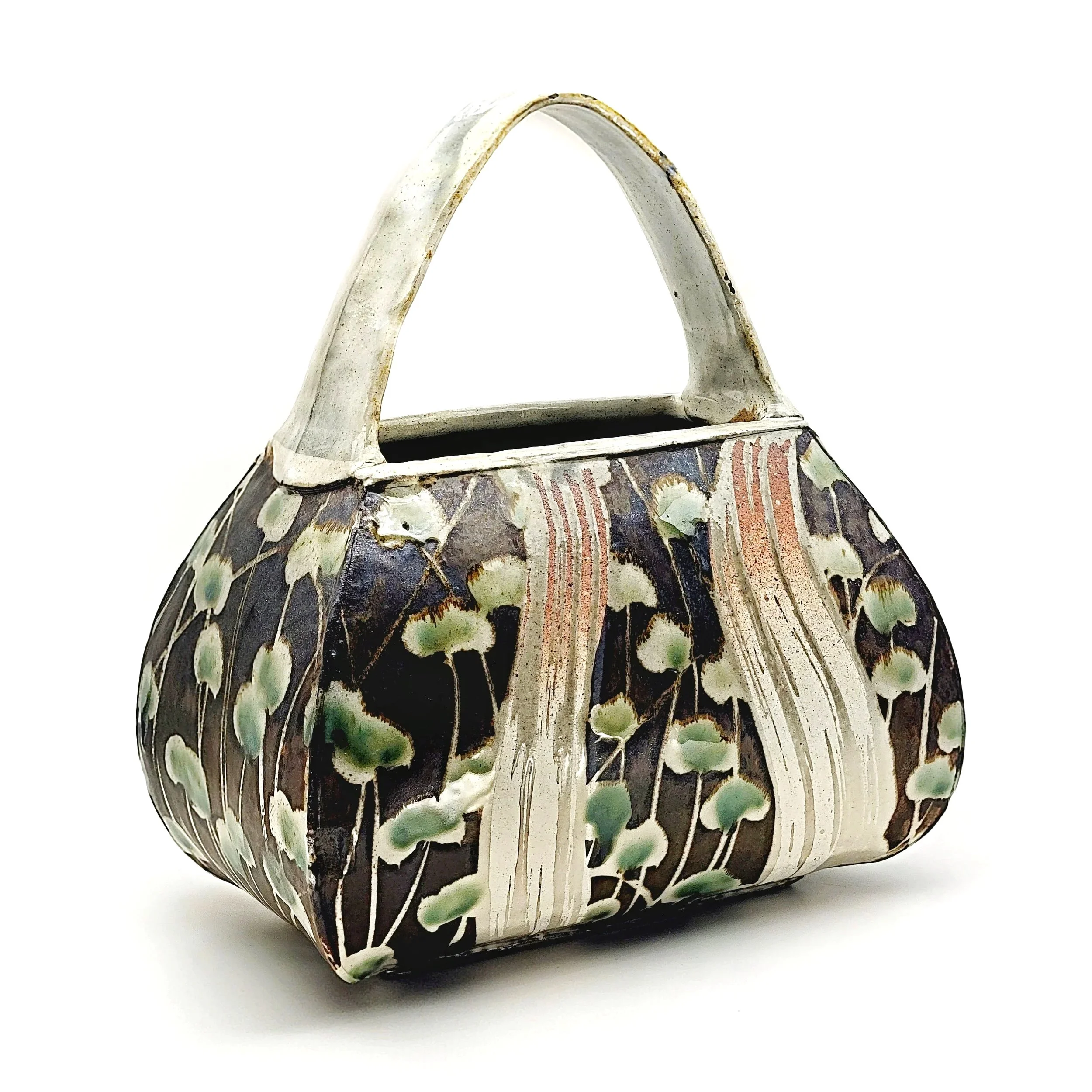 Ceramic basket with floral pattern and a curved handle, decorated with green leaves and brown, white, and pink accents.