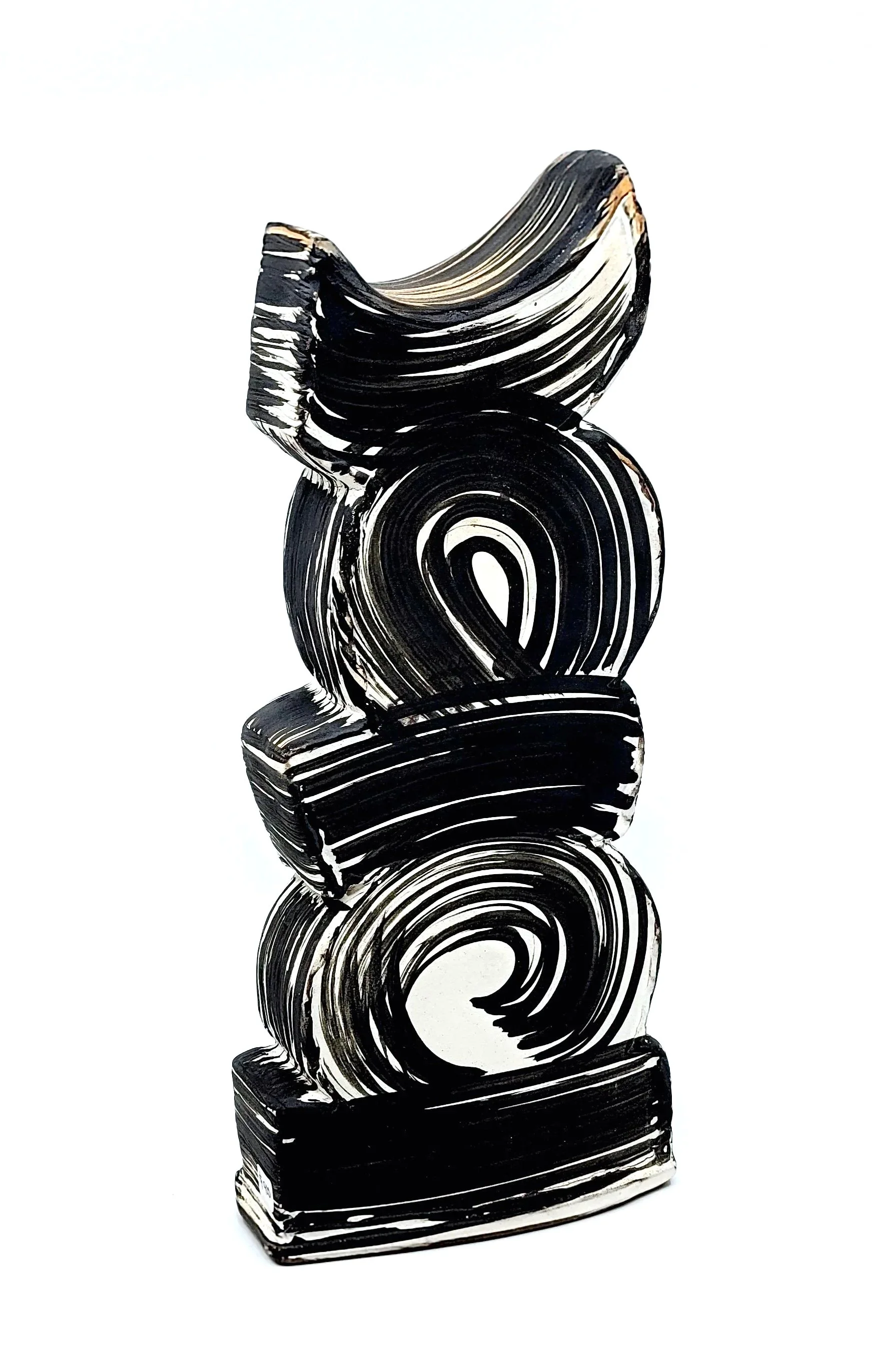 A tall abstract sculpture with black and white swirling patterns, composed of several interconnected spiral and curved shapes, standing on a white background.