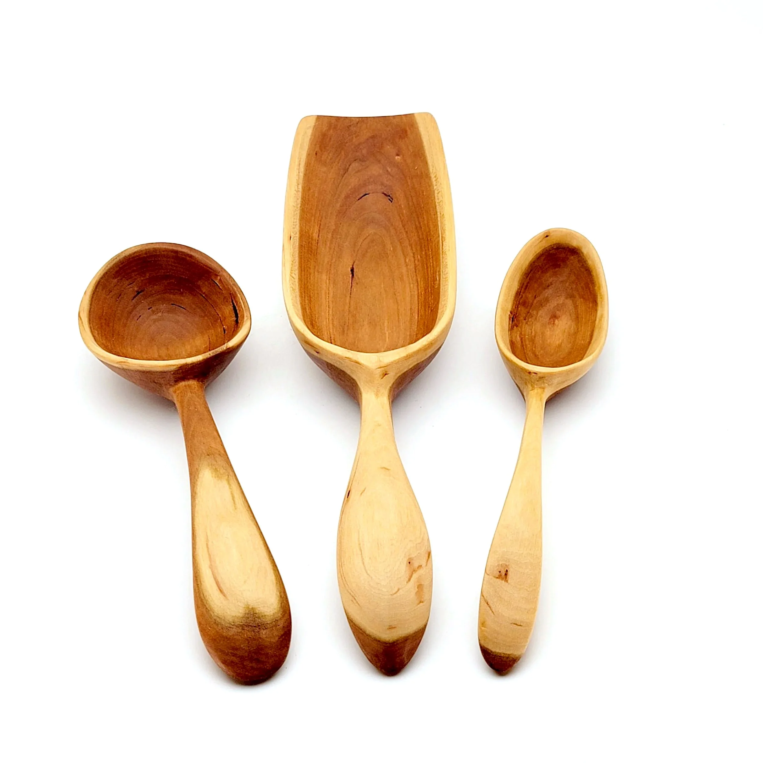 Three wooden scoops in different sizes against a white background.
