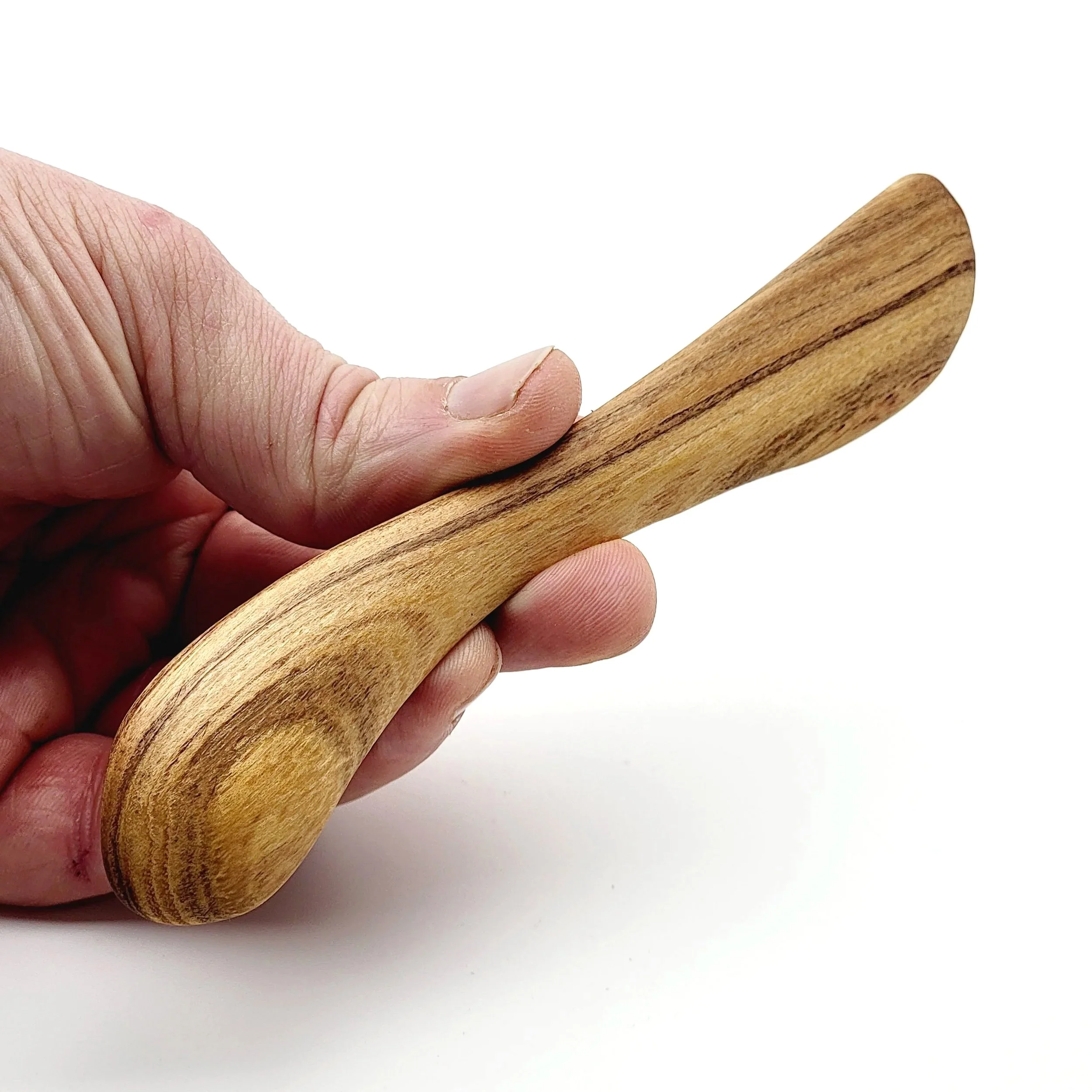 Close-up of a hand holding a wooden spatula against a plain white background.