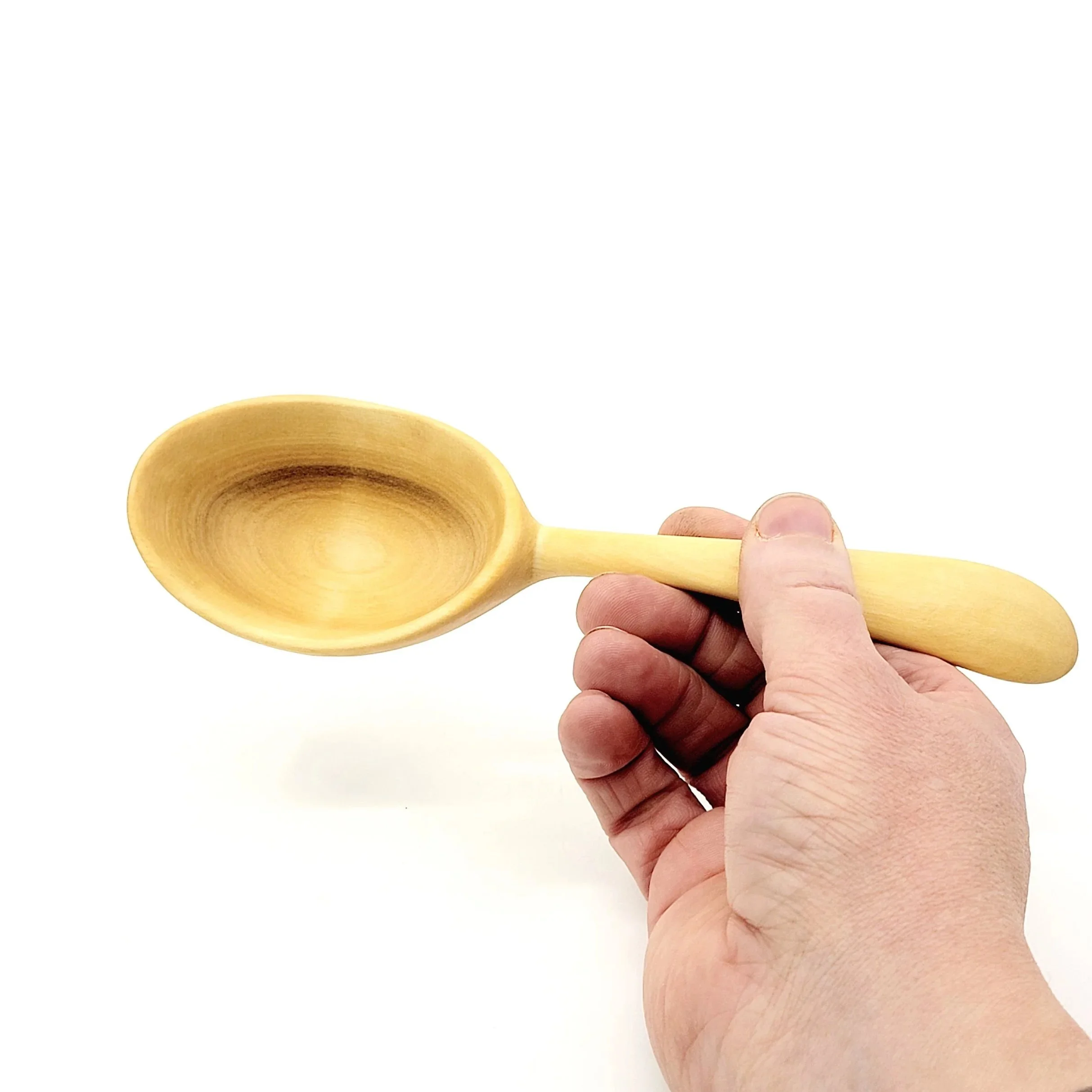 Hand holding a wooden spoon over a plain white background.