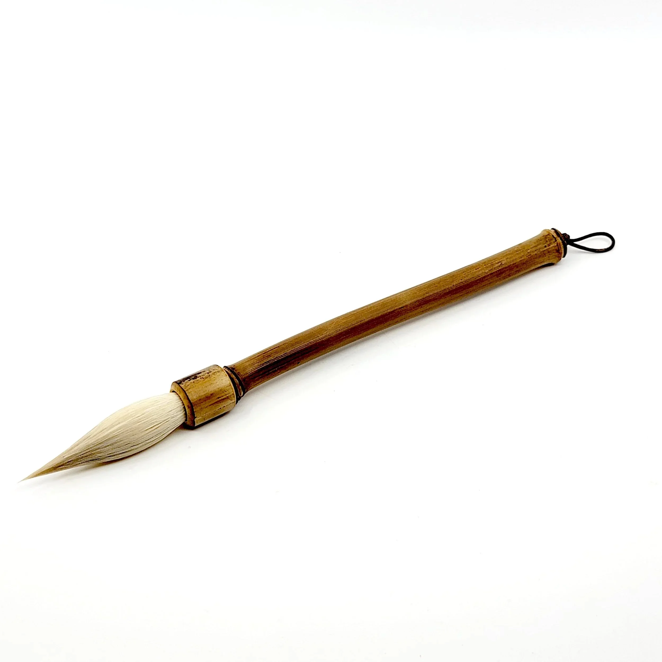 Traditional bamboo brush with beige bristles and a black loop on the handle placed on a white background.