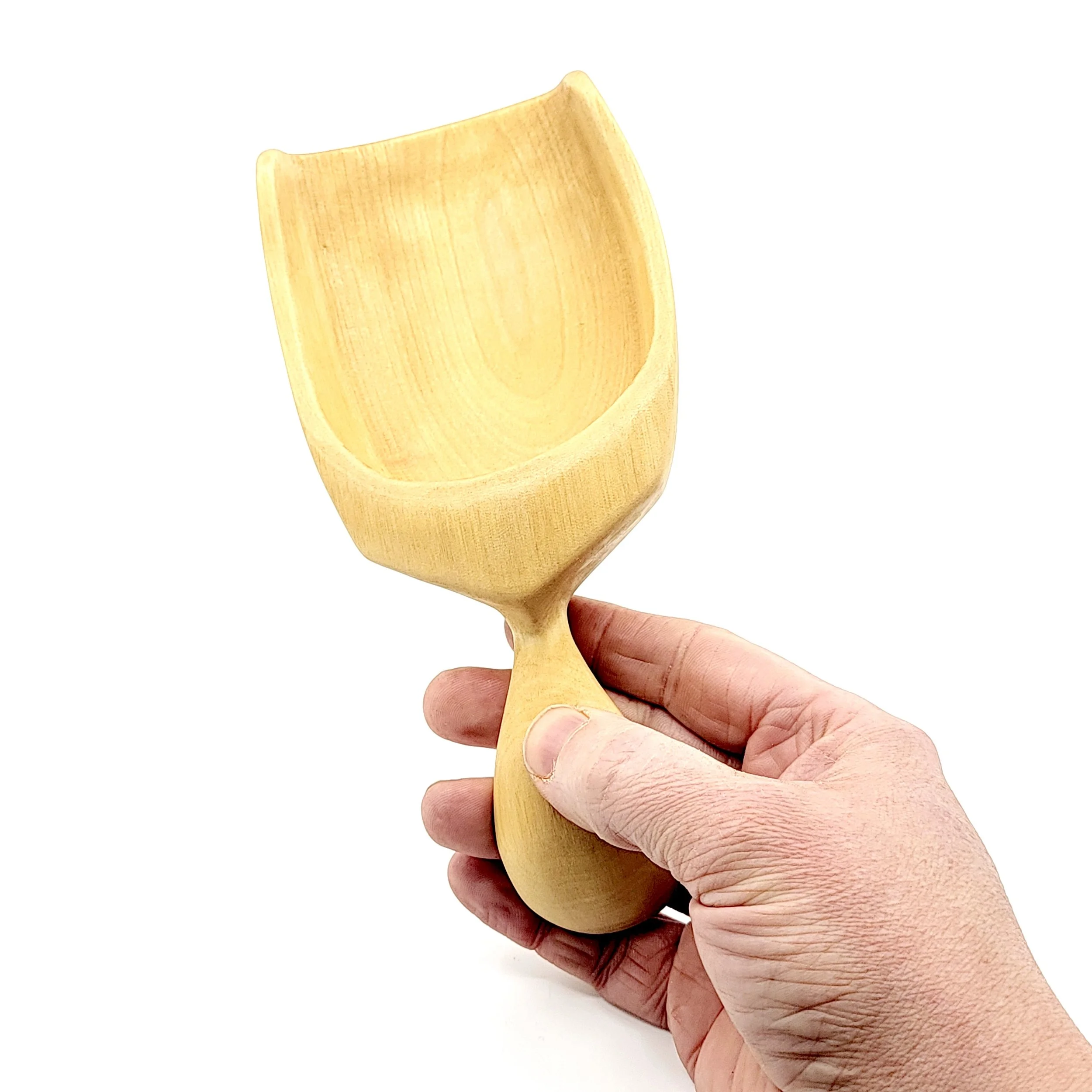 A hand holding a small, unfinished wooden scoop with a rectangular bowl and a rounded handle