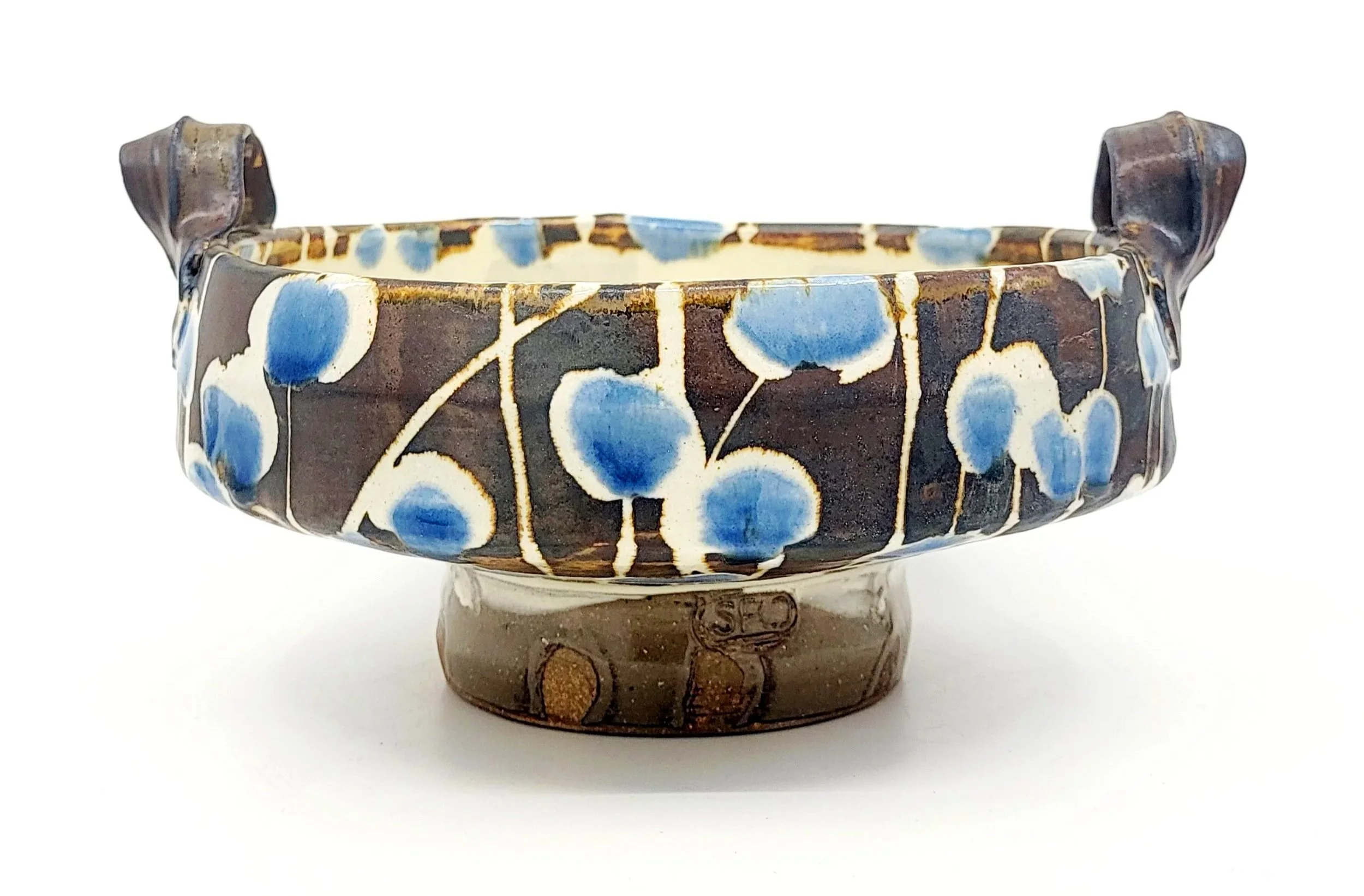 Ceramic bowl with blue floral pattern and a small base, glazed in brown and blue colors.