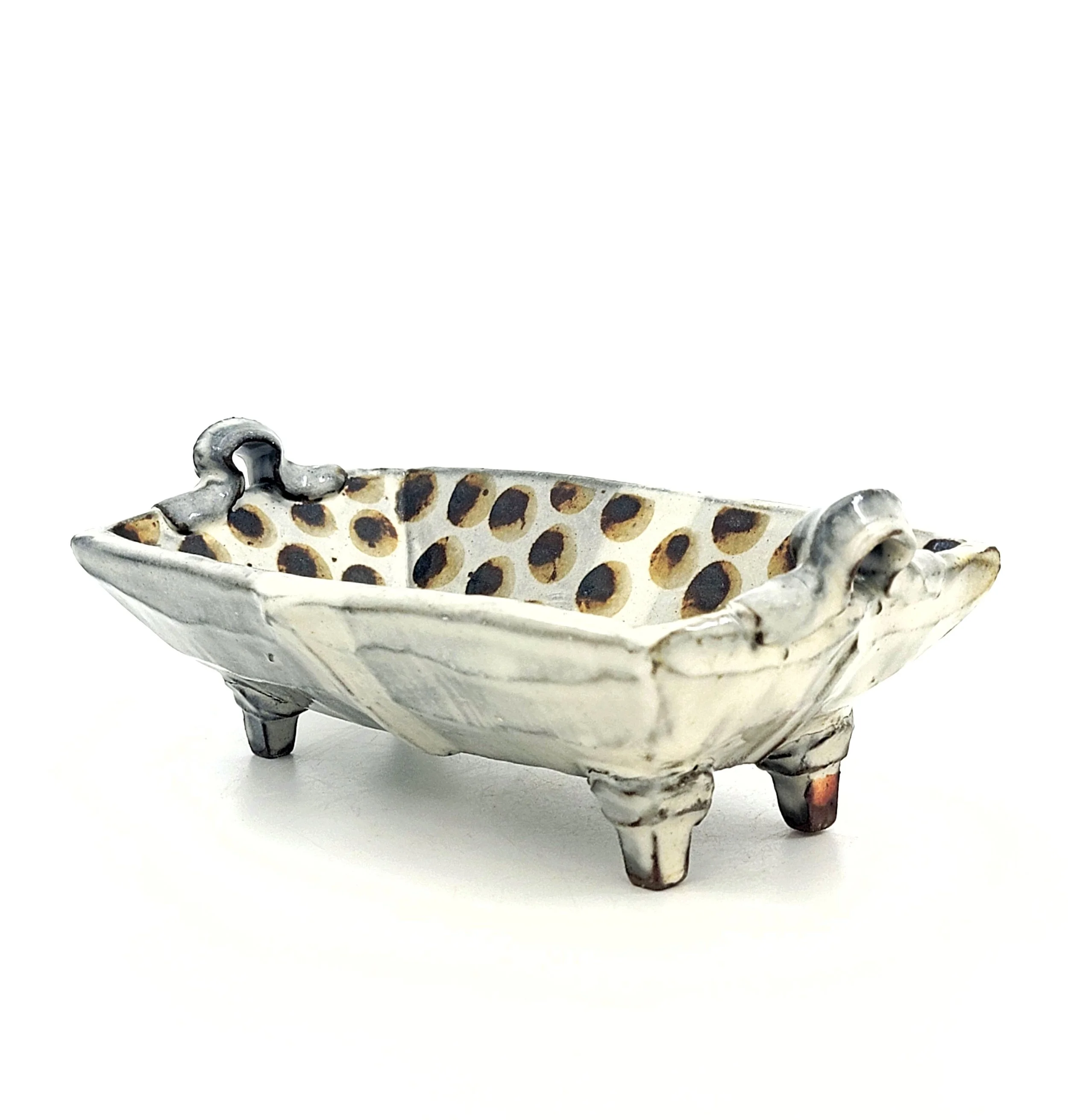 Ceramic decorative dish with three small legs, animal claw handles, and a dotted interior design.