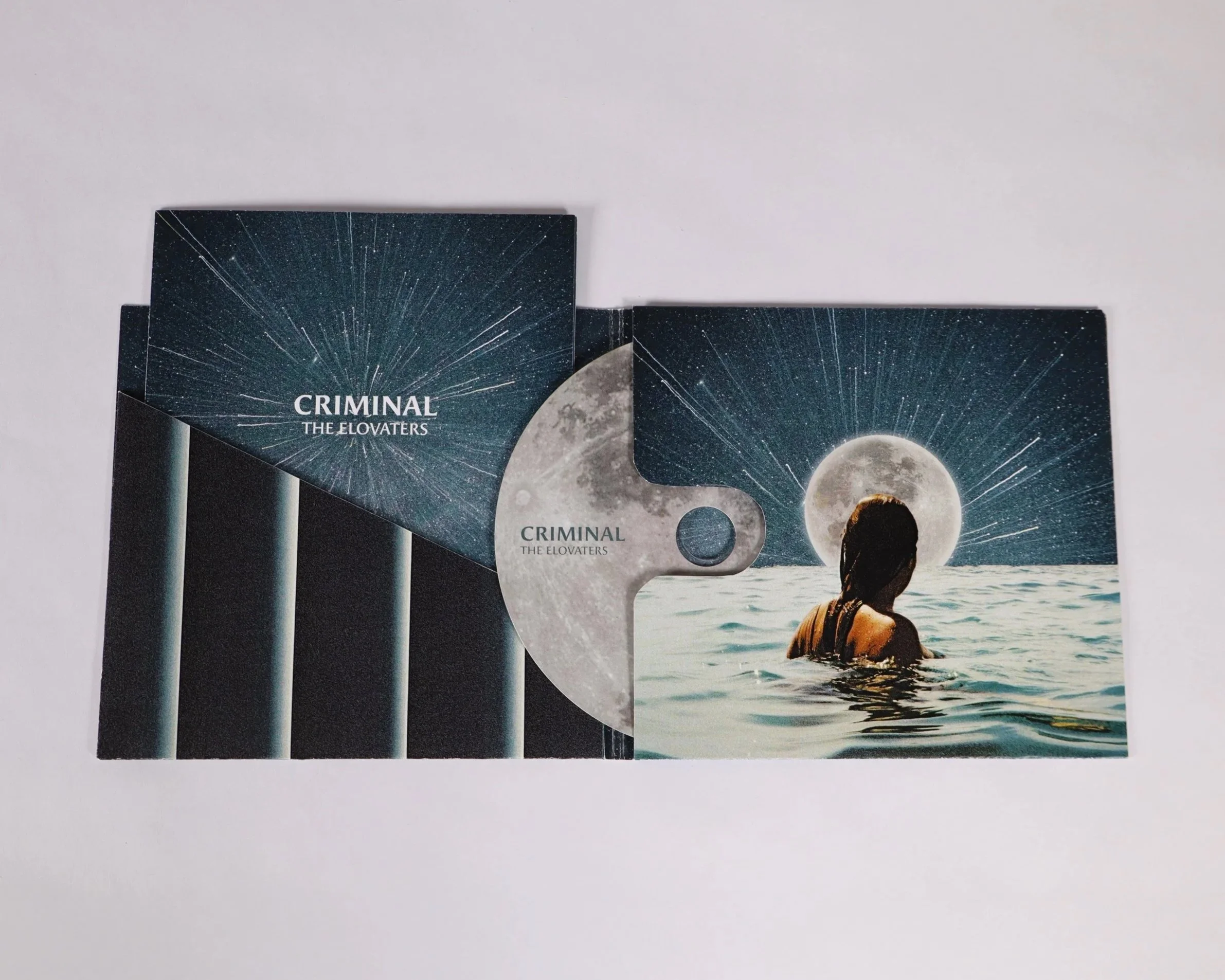 An album cover and CD titled 'Criminal' by 'The Elovaters'. The cover features a woman in water with a full moon and stars in the sky, and the CD has a moon design.
