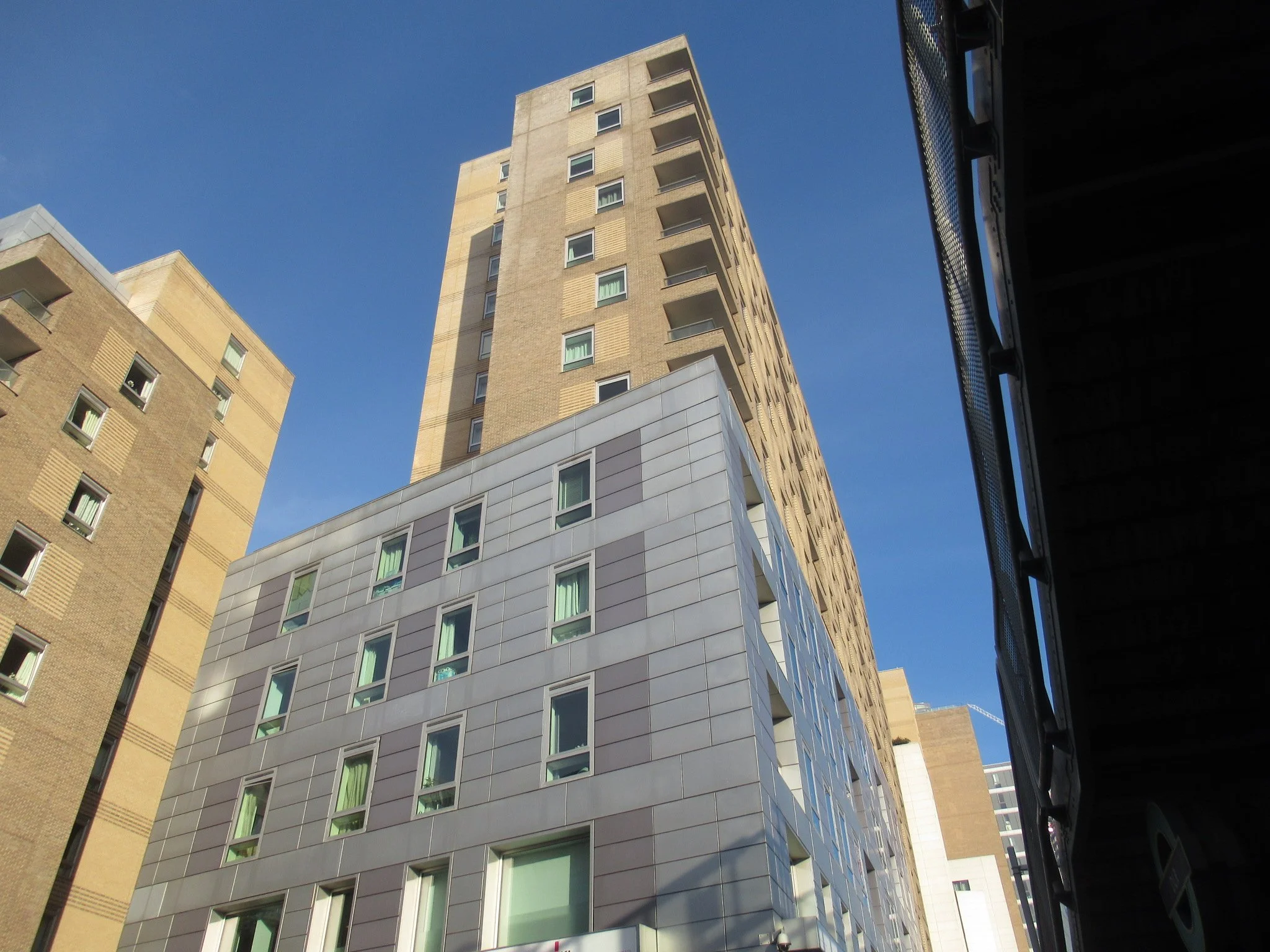 Low-angle view of modern high-rise buildings against a clear blue sky.