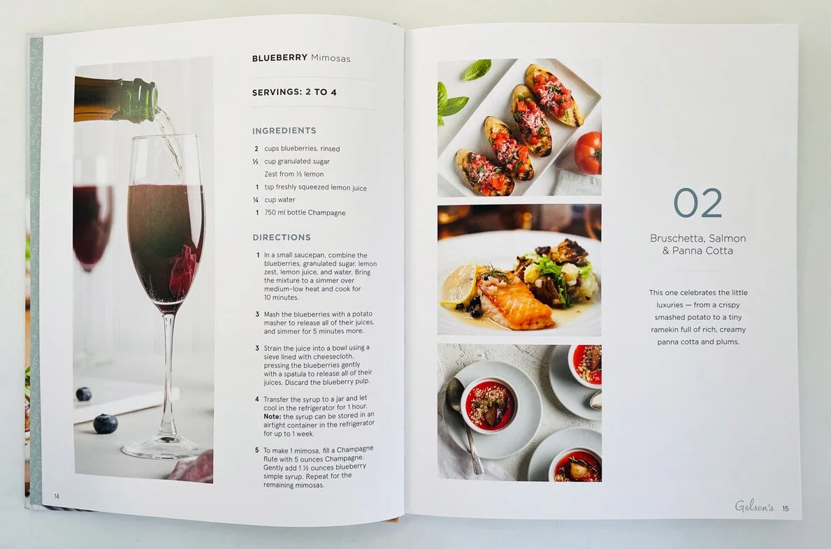 Open cookbook showing a blueberry mimosa recipe on the left page and images of bruschetta, salmon, and panna cotta desserts on the right page.