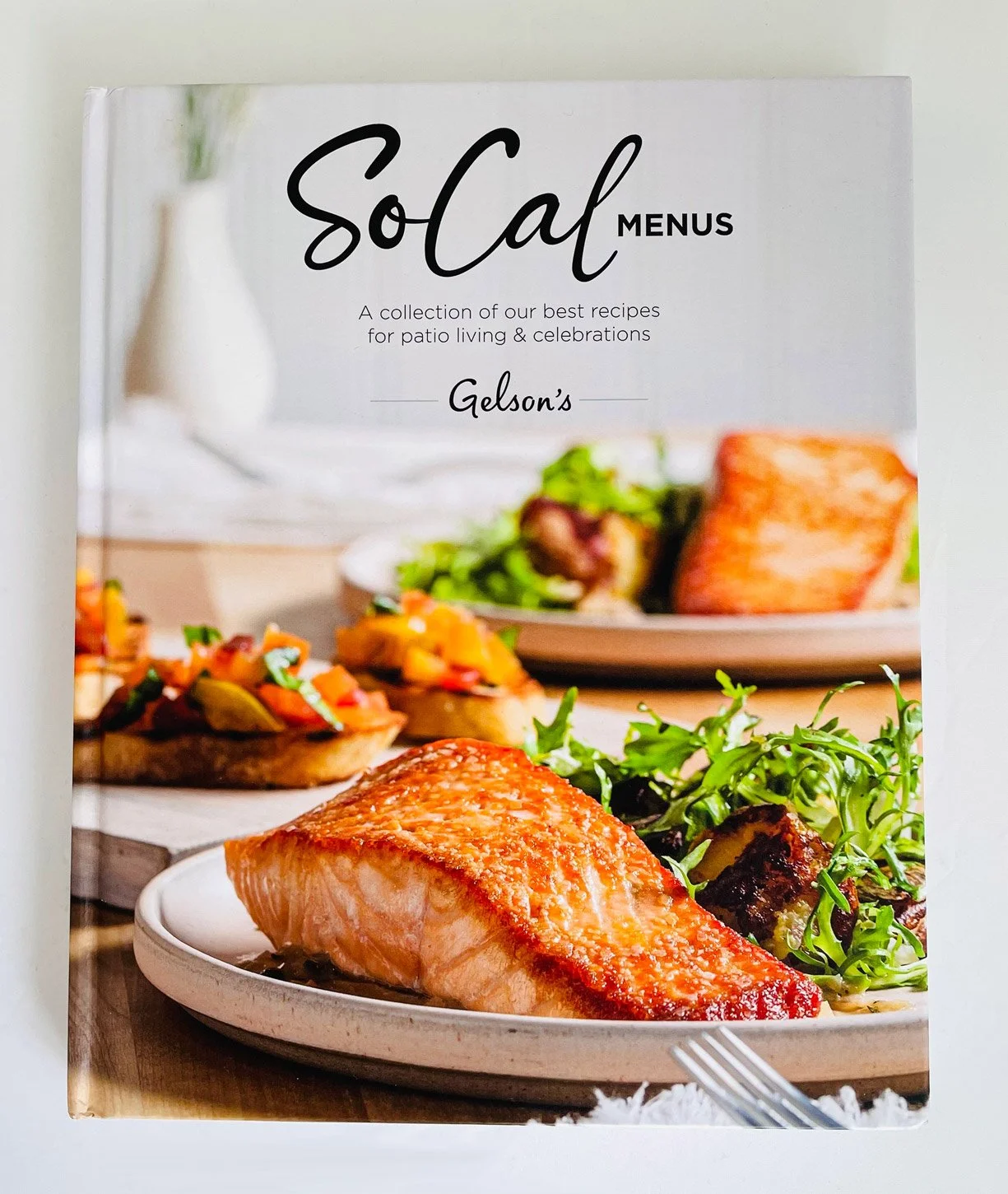Book cover titled 'SoCal Menus' featuring a salmon fillet on a white plate, with side salads and bruschetta in the background.