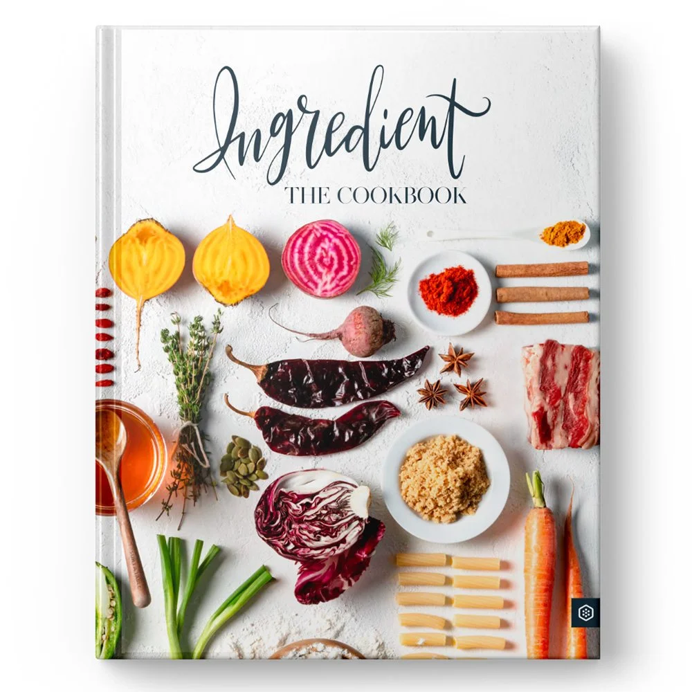 Cover of an ingredient cookbook featuring various cooking ingredients including vegetables, spices, and herbs arranged on a white surface.