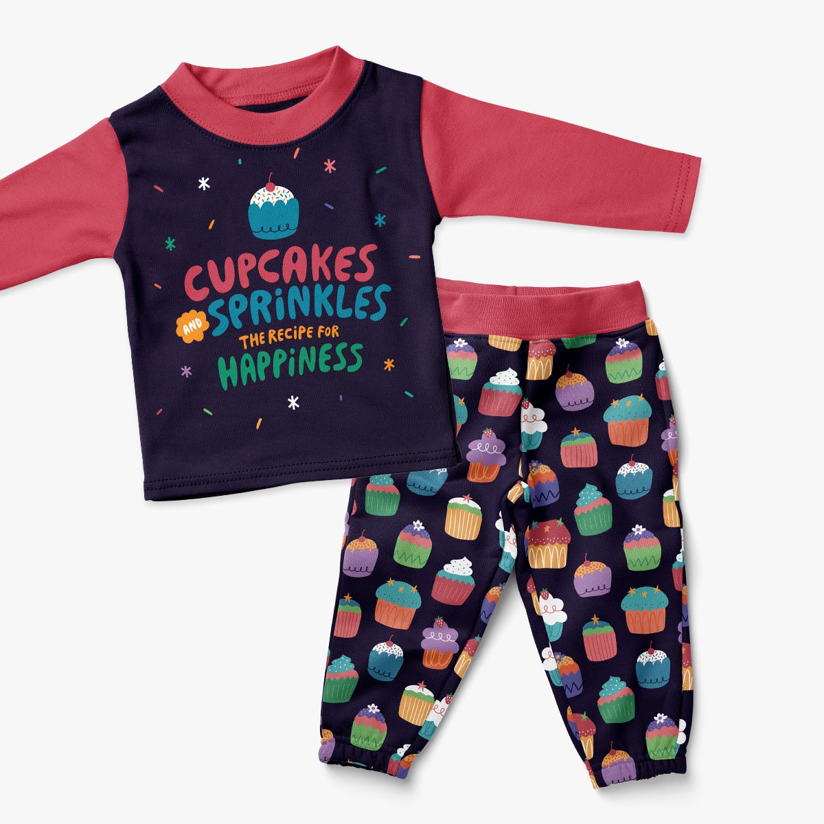 Children's pajamas set with a dark blue top featuring colorful text and a cupcake illustration, and matching pants with cupcake pattern.