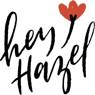Black hand-lettered script logo that says "Hey Hazel" with a dark orange flower.