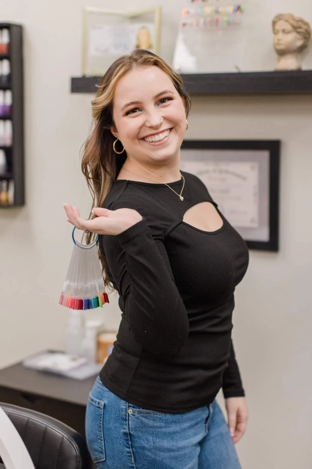 Young woman smiling in an office holding a set of color swatches.