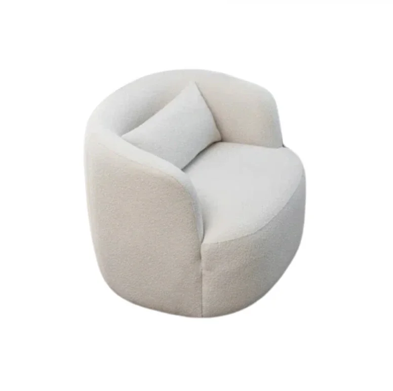 A modern, round, white upholstered armchair with a matching small pillow on one side.