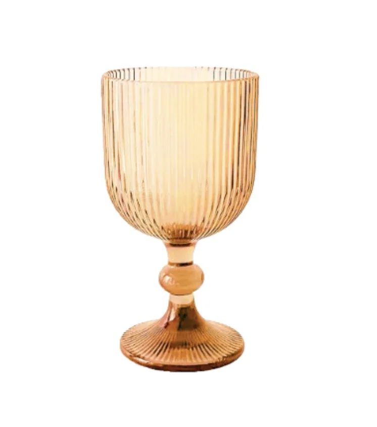 A gold-colored drinking glass with vertical ridges, a rounded base, and a short stem.