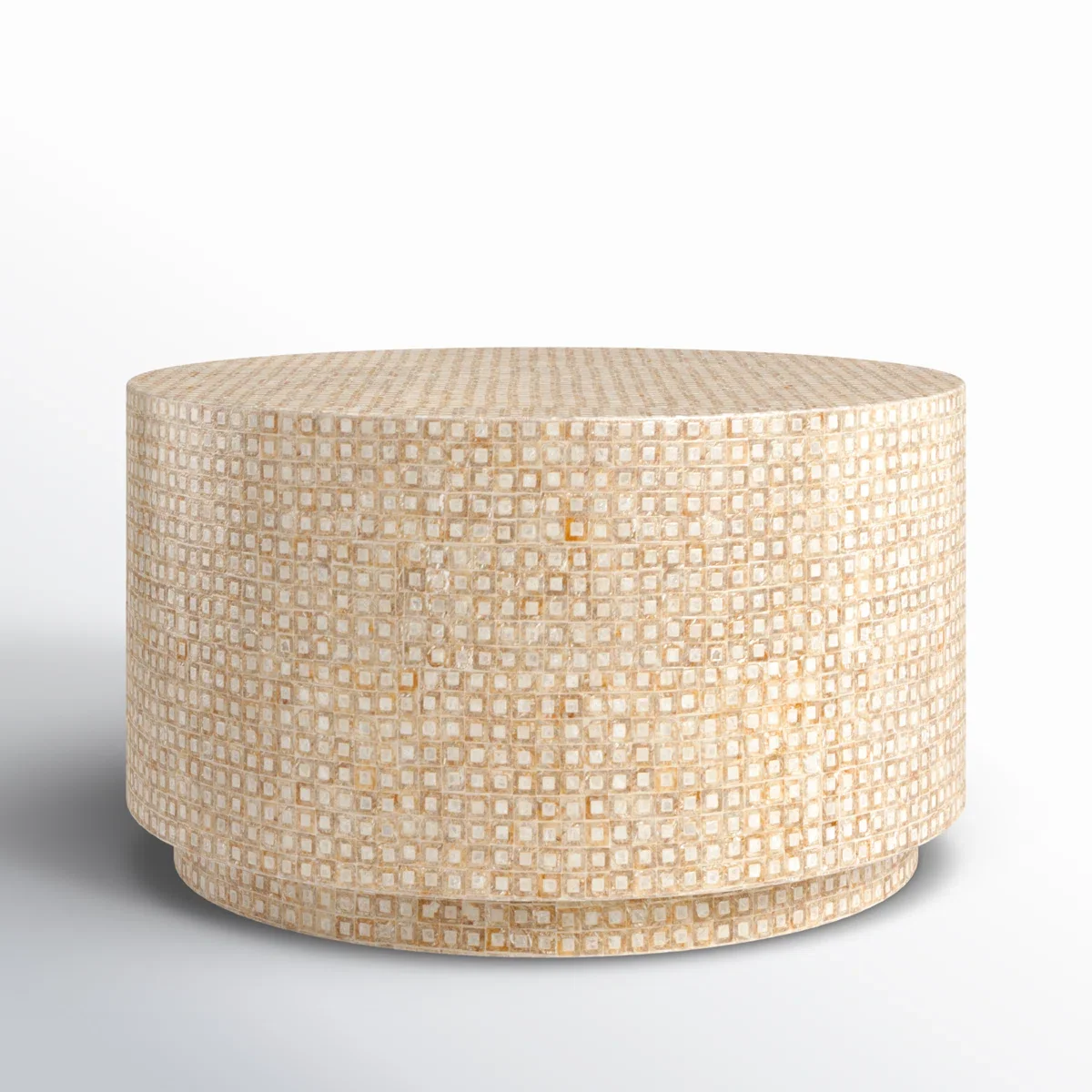 A round, beige-colored ottoman with a mosaic tile pattern on its surface, set against a plain white background.