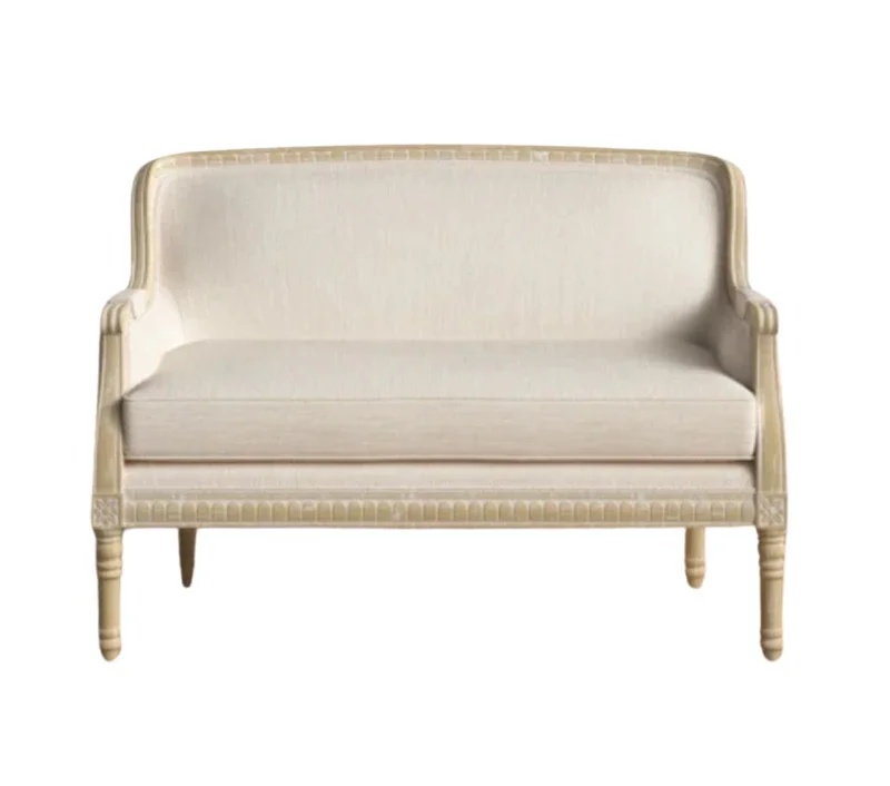 A white vintage-style sofa with carved wooden legs and armrests, set against a plain white background.