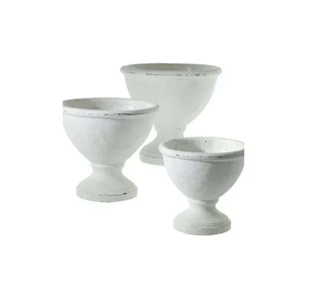 Set of three white ceramic bowls with short stems and rounded bases.