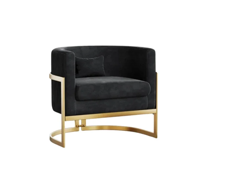 A modern black armchair with gold metal legs and a matching black pillow.