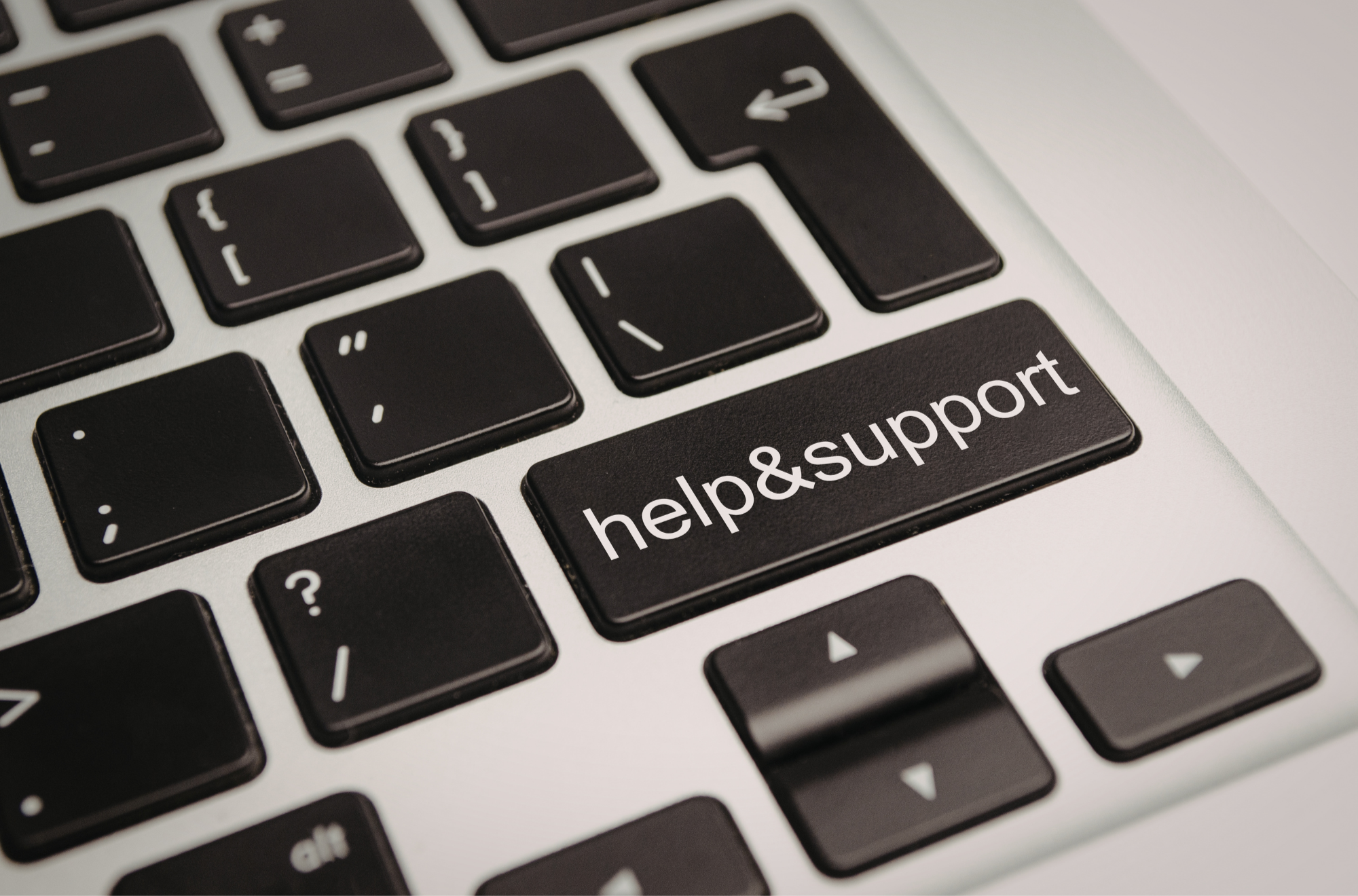 Close-up of a computer keyboard with the 'help & support' key highlighted.