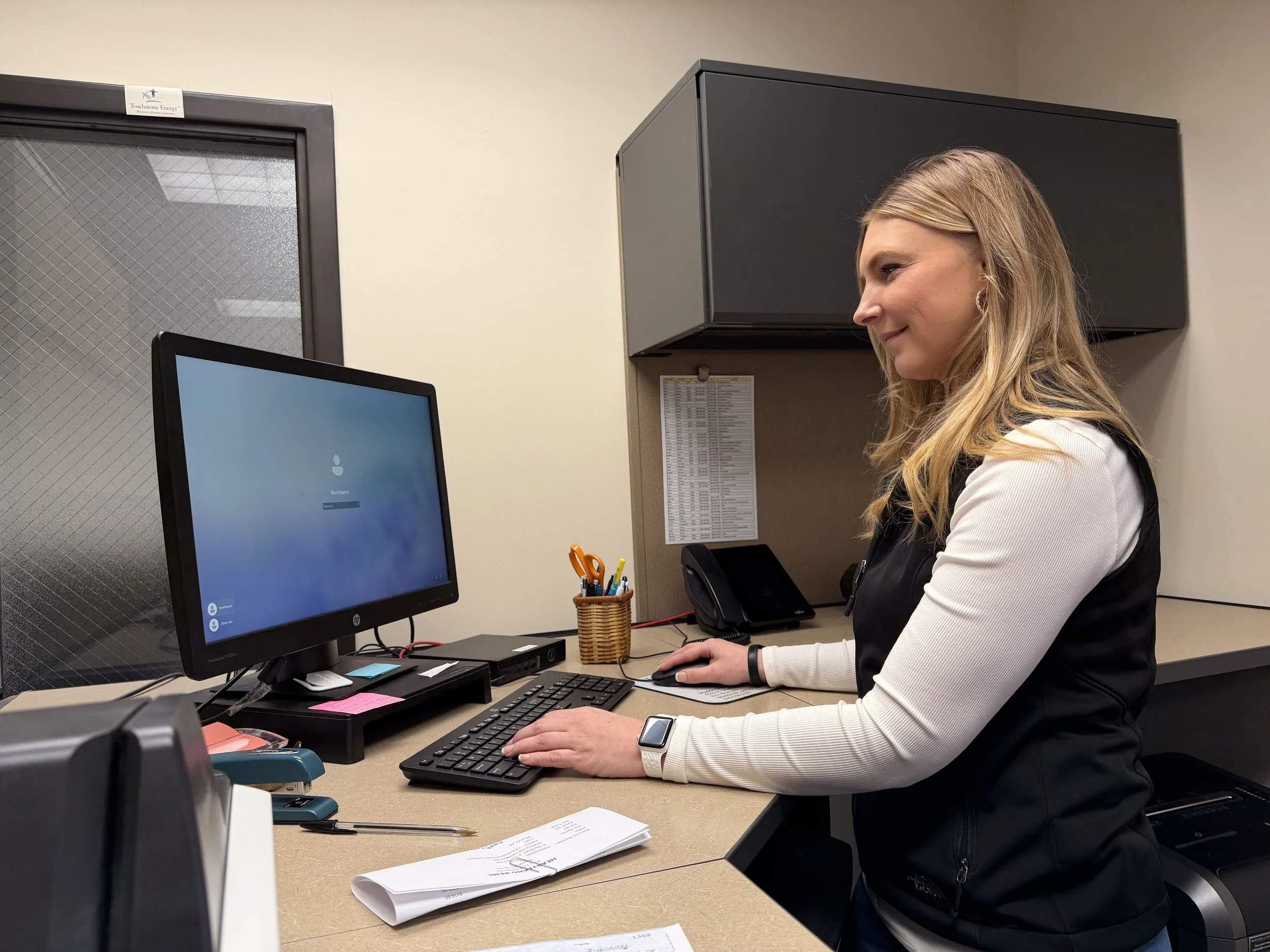 Customer support representative working at a desk with a monitor