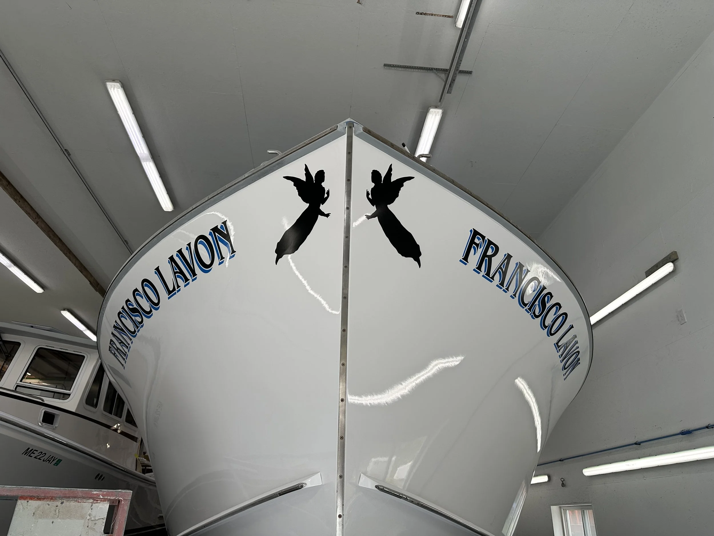 View of the bow of a boat with black and blue lettering