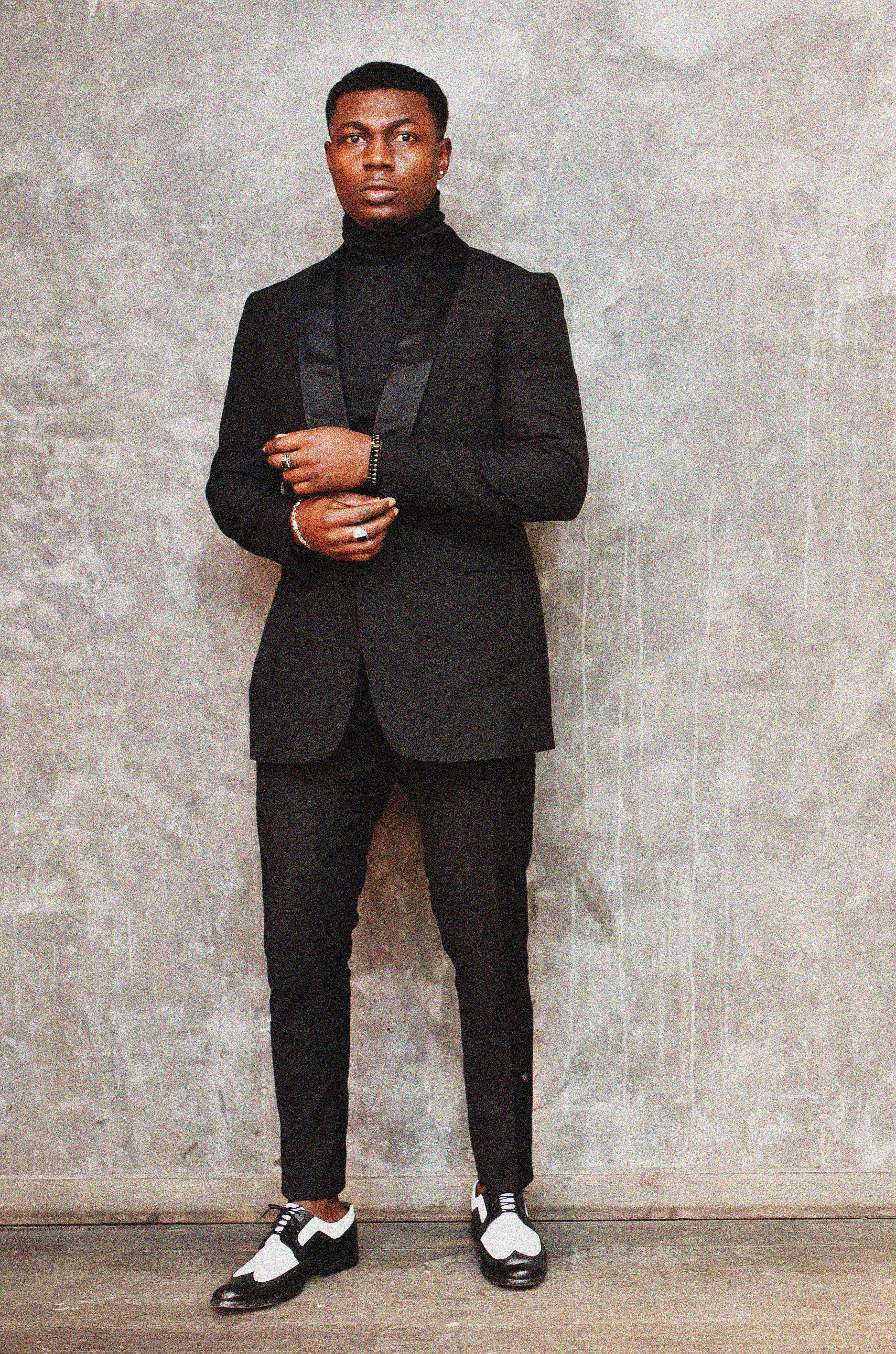 strong-powerful-african-american-man-black-suit-turtleneck-posing-against-grey-wall.jpg