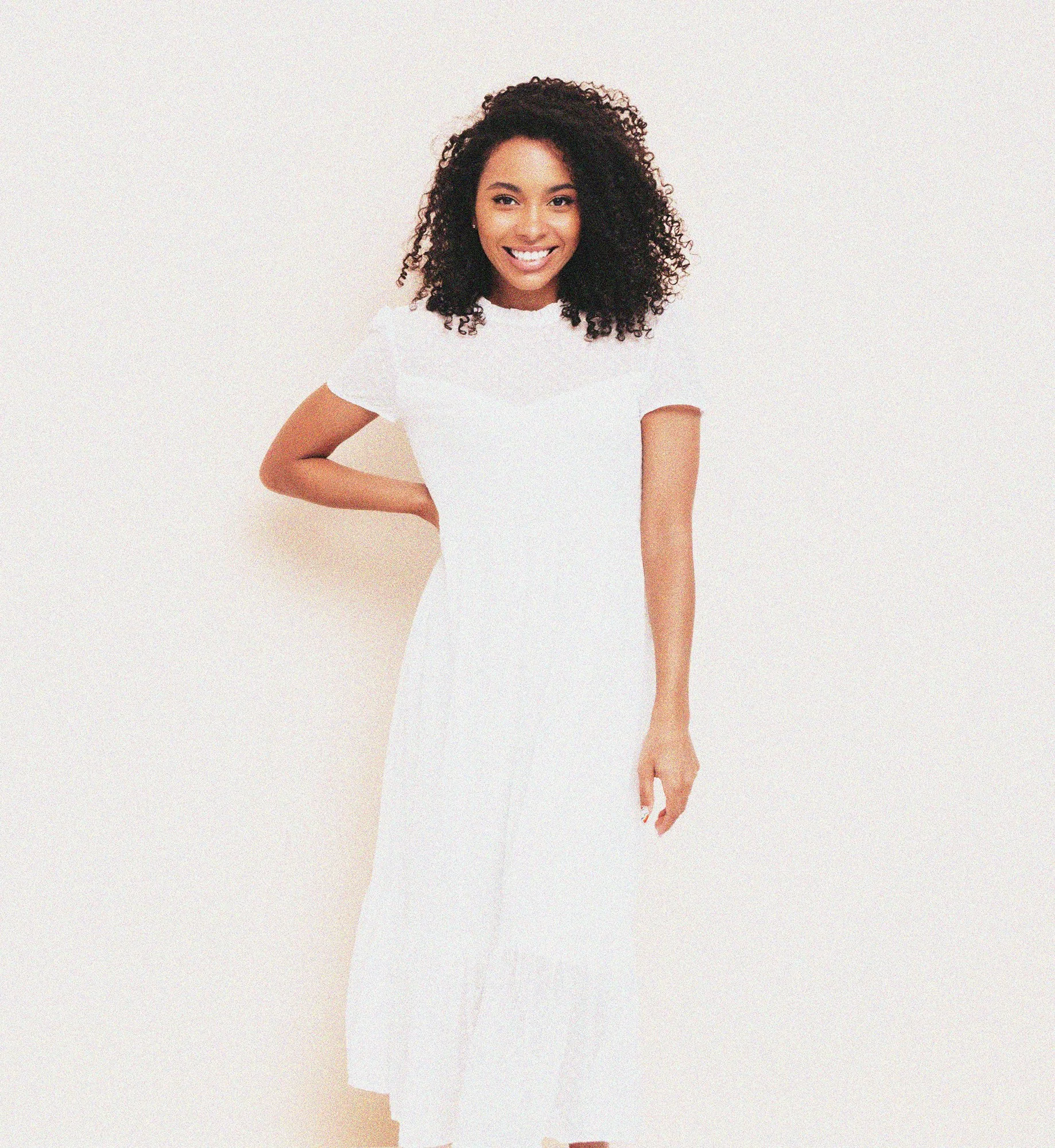 beautiful-black-woman-with-afro-curls-hairstyle-smiling-model-dressed-white-summer-dress-sexy-carefree-female-posing-near-wall-studio-tanned-cheerful-isolated.jpg
