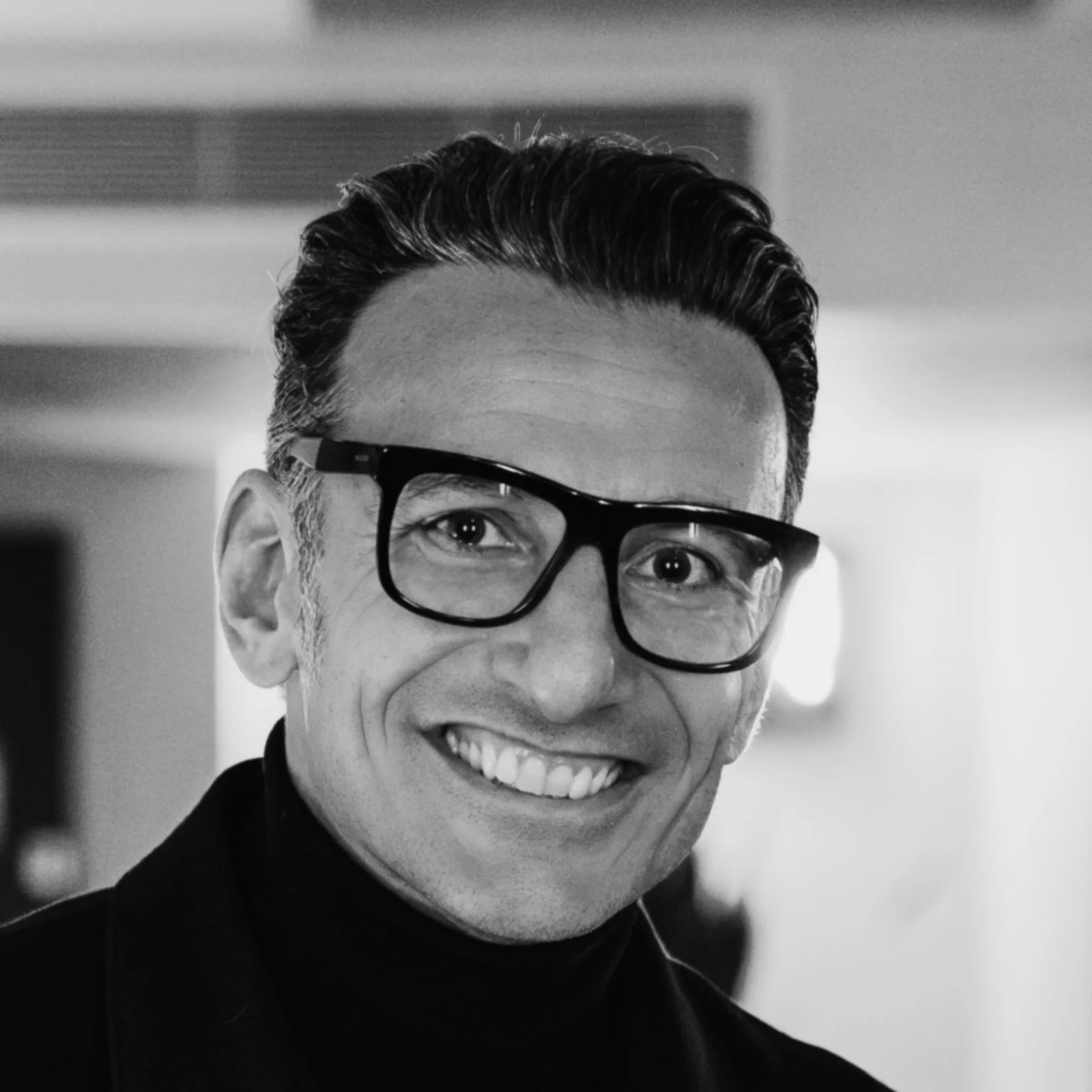 Smiling person wearing glasses in a black and white photo