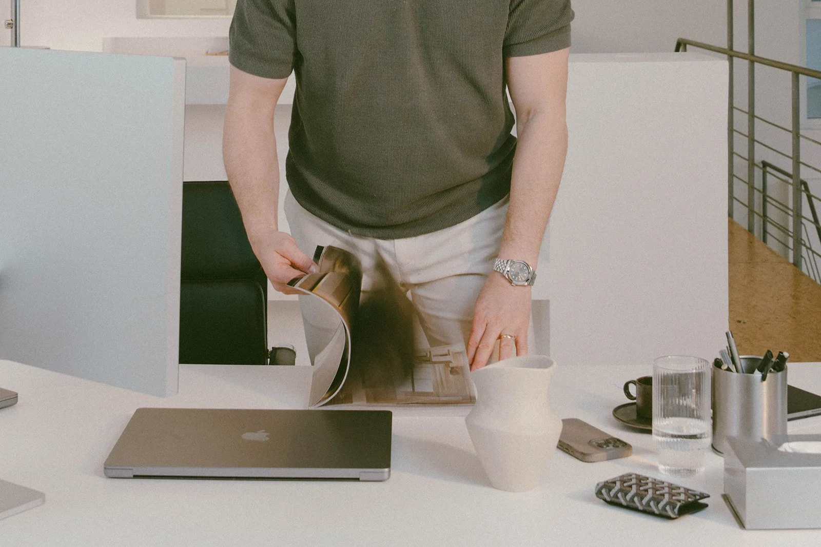 Arbeitsplatz mit Laptop, Bildschirm und Unterlagen in heller Studio-Umgebung