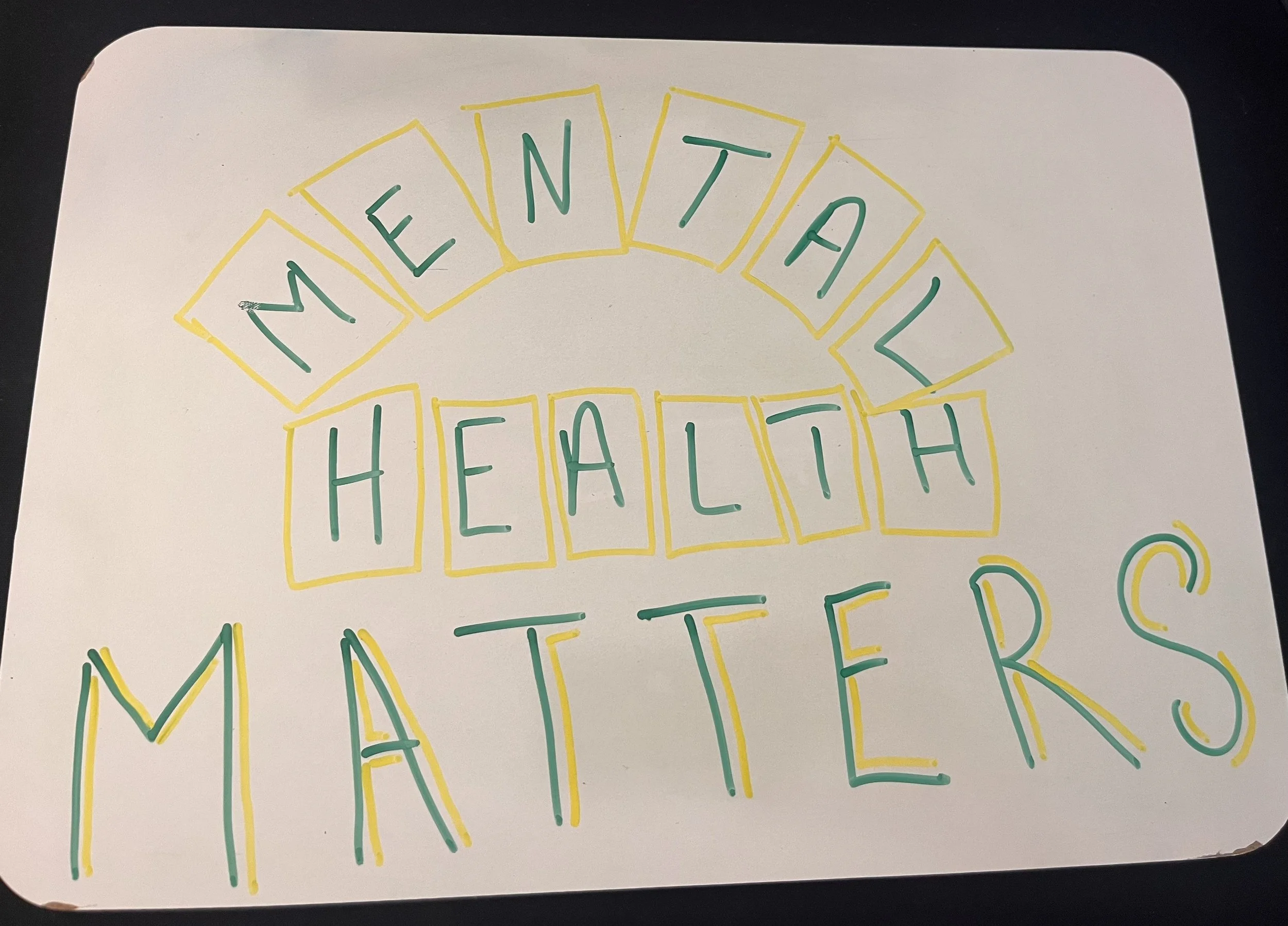 Handwritten sign that says "WEEKEND HEALTH" in colorful markers, with each letter inside individual rectangular boxes.