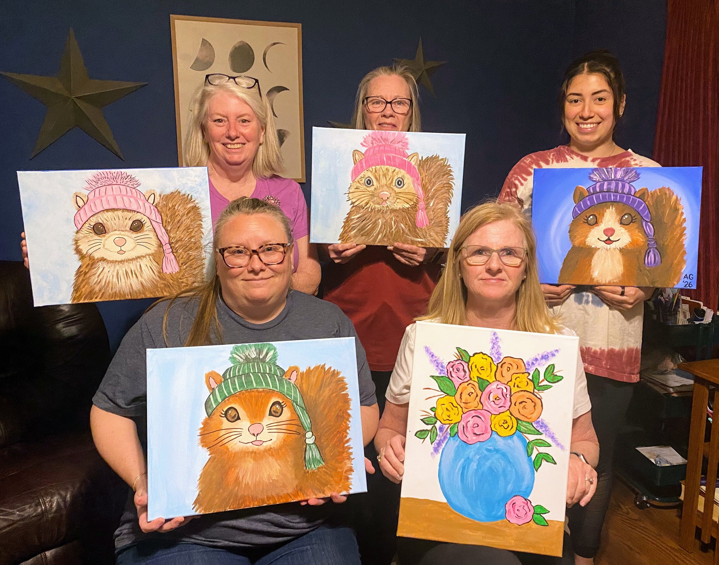 Friends holding paintings