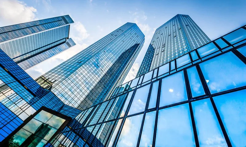 Image of reflective windows on tall high rise buildings in large city, showing dangers of bird-window collisions