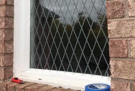 Decorative film in criss-cross pattern applied to exterior home window for bird-safe window treatment