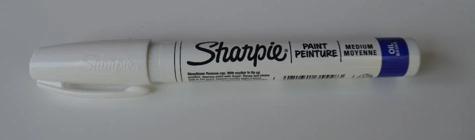 Close up of Sharpie oil based paint marker on a white background