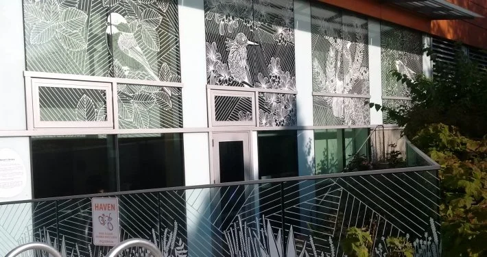 Close up of windows treated with floral and foliage designs across University of British Columbia buildings to prevent fatal bird-window collisions