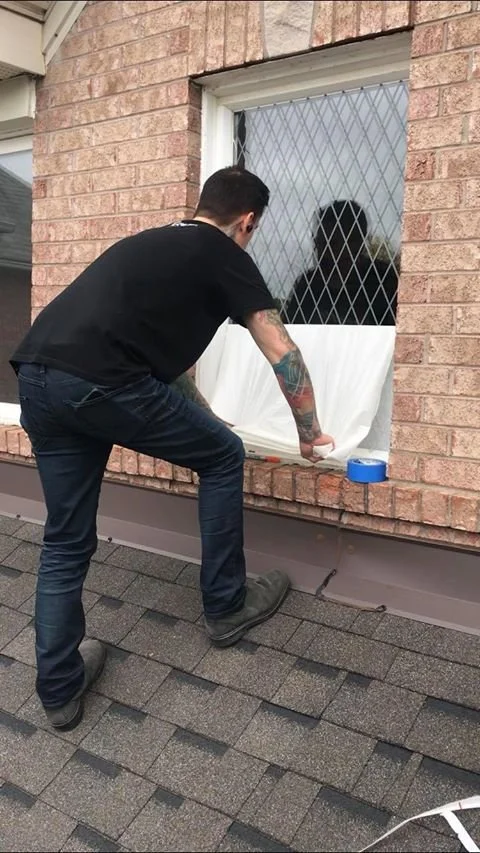 Man applying bird-safe-window solution on a residential home window