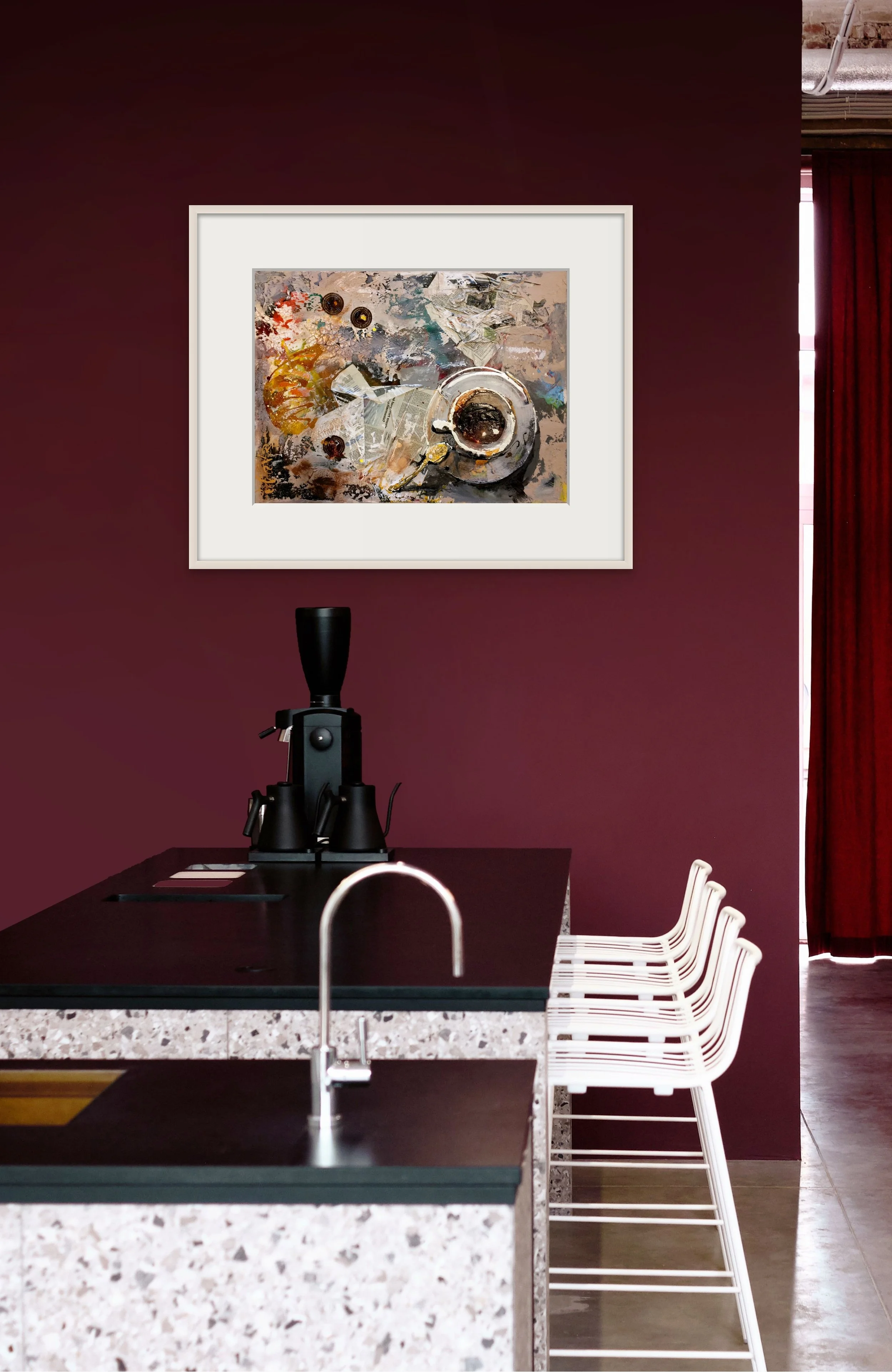 A modern kitchen or café area with a deep maroon wall, white bar stools, a black coffee grinder, and a framed abstract painting on the wall.