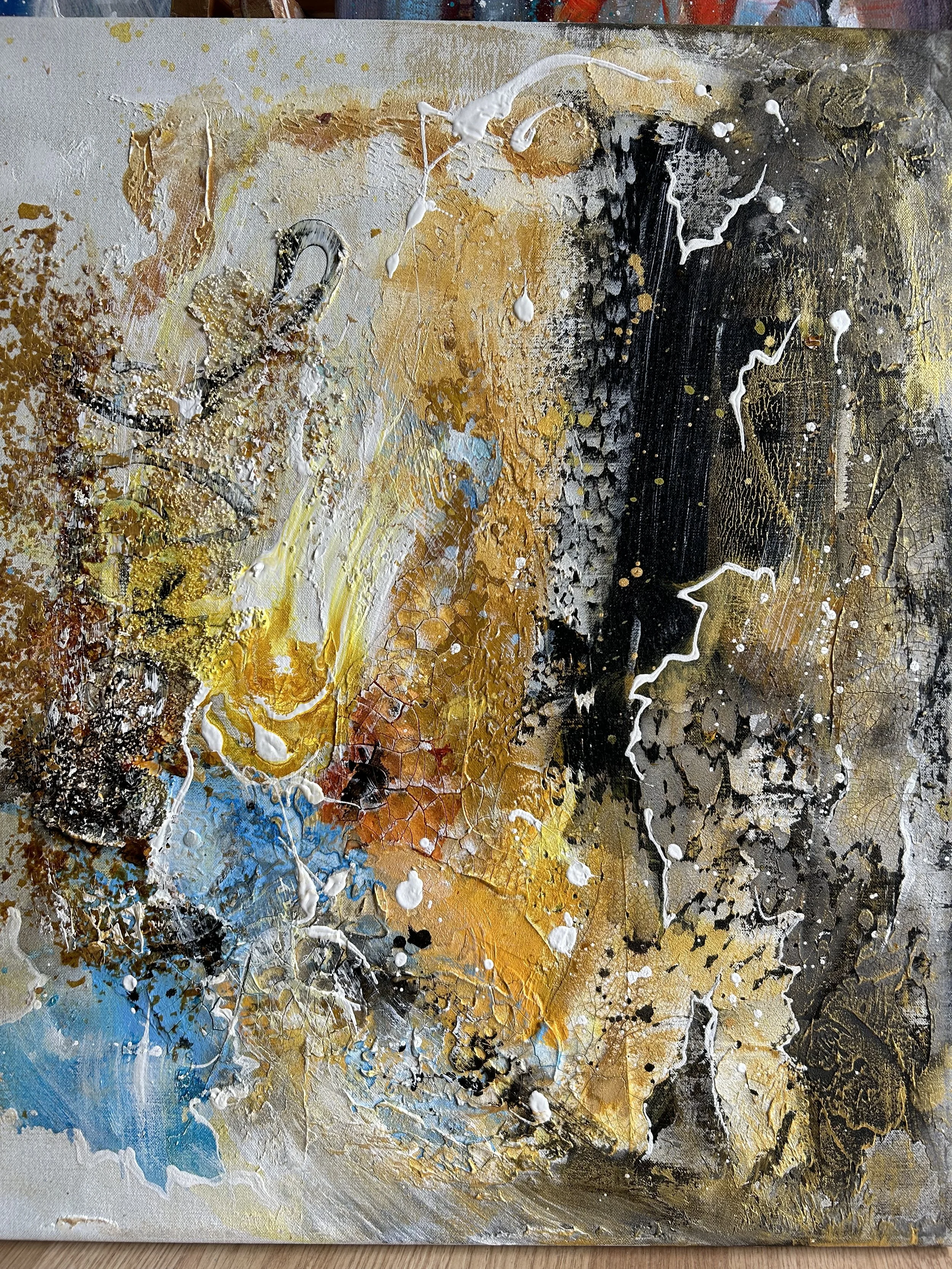 Abstrakt maleri med gule, blå, sorte, hvide, brune og grå nuancer med tekstur og sprøjtemaling.