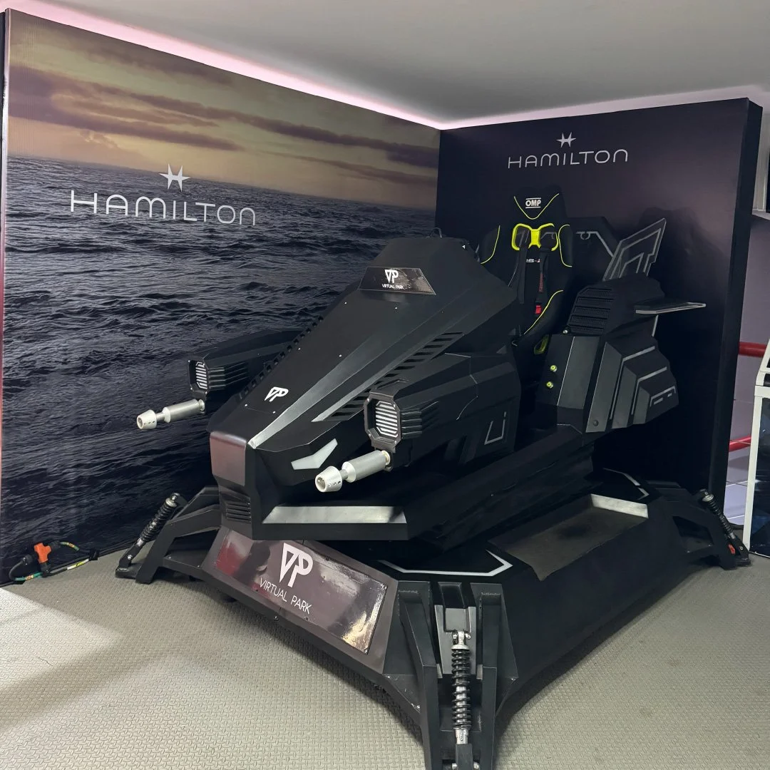 Simulador de carrera de alta tecnología para motocicleta de nieve con diseño futurista y pantalla digital en un entorno de parque virtual.