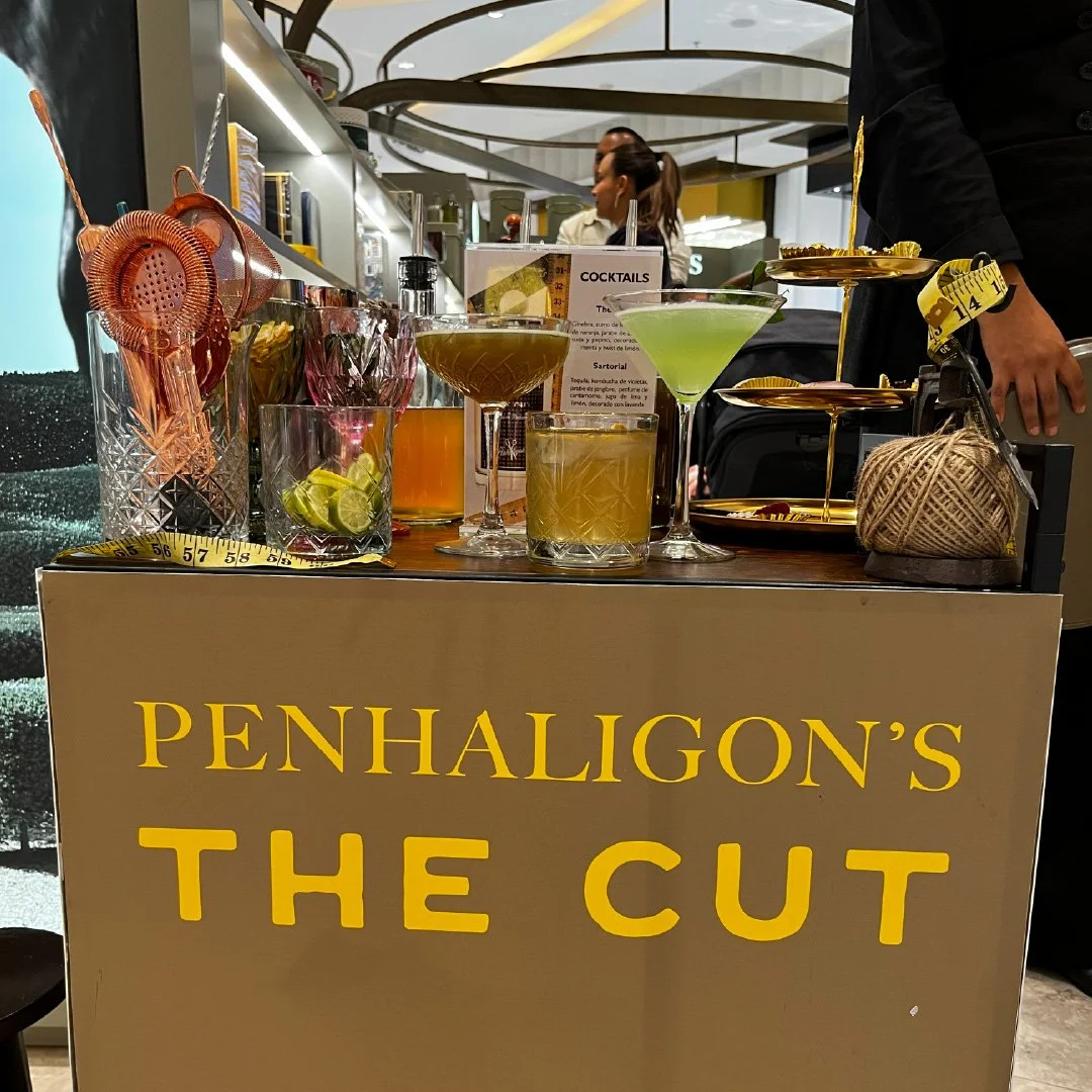 Varios cócteles sobre una mesa en un bar con un cartel que dice 'Penhaligon's the cut'. activacion pdv