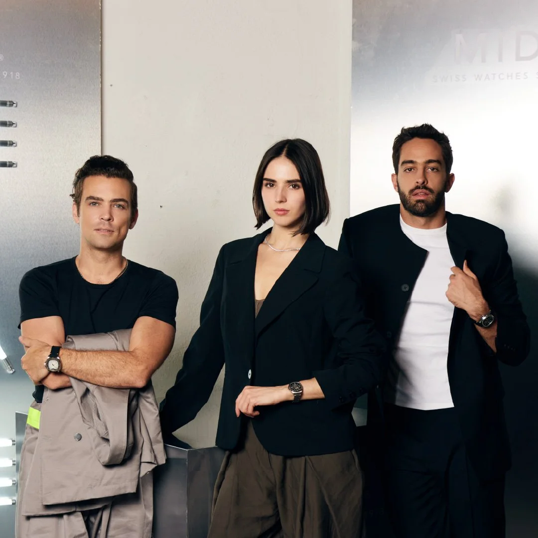 Tres personas adultas en un entorno moderno, posando para la cámara en actitud segura y confiada.