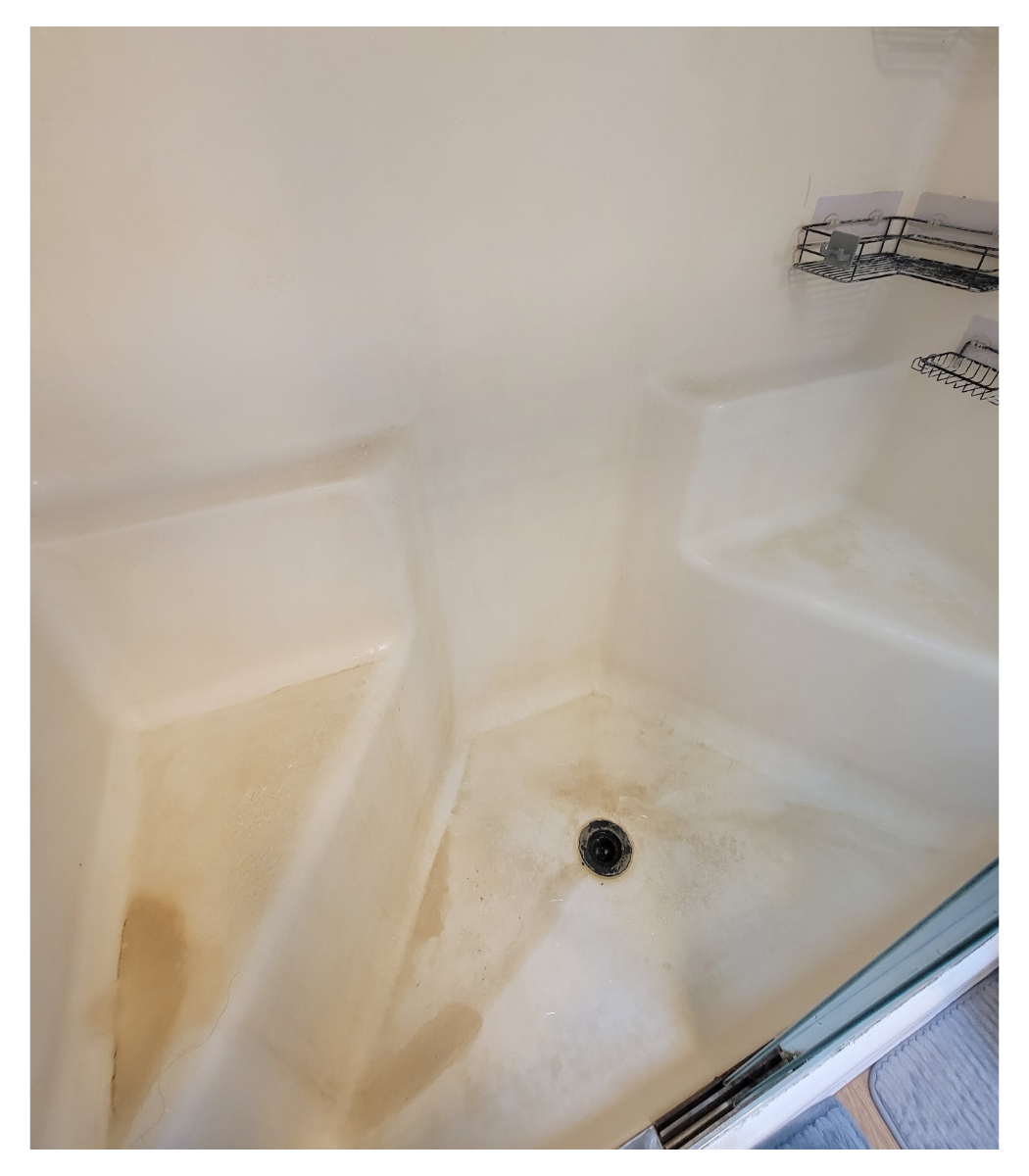 Before picture of a very dirty shower base with grime and stains.