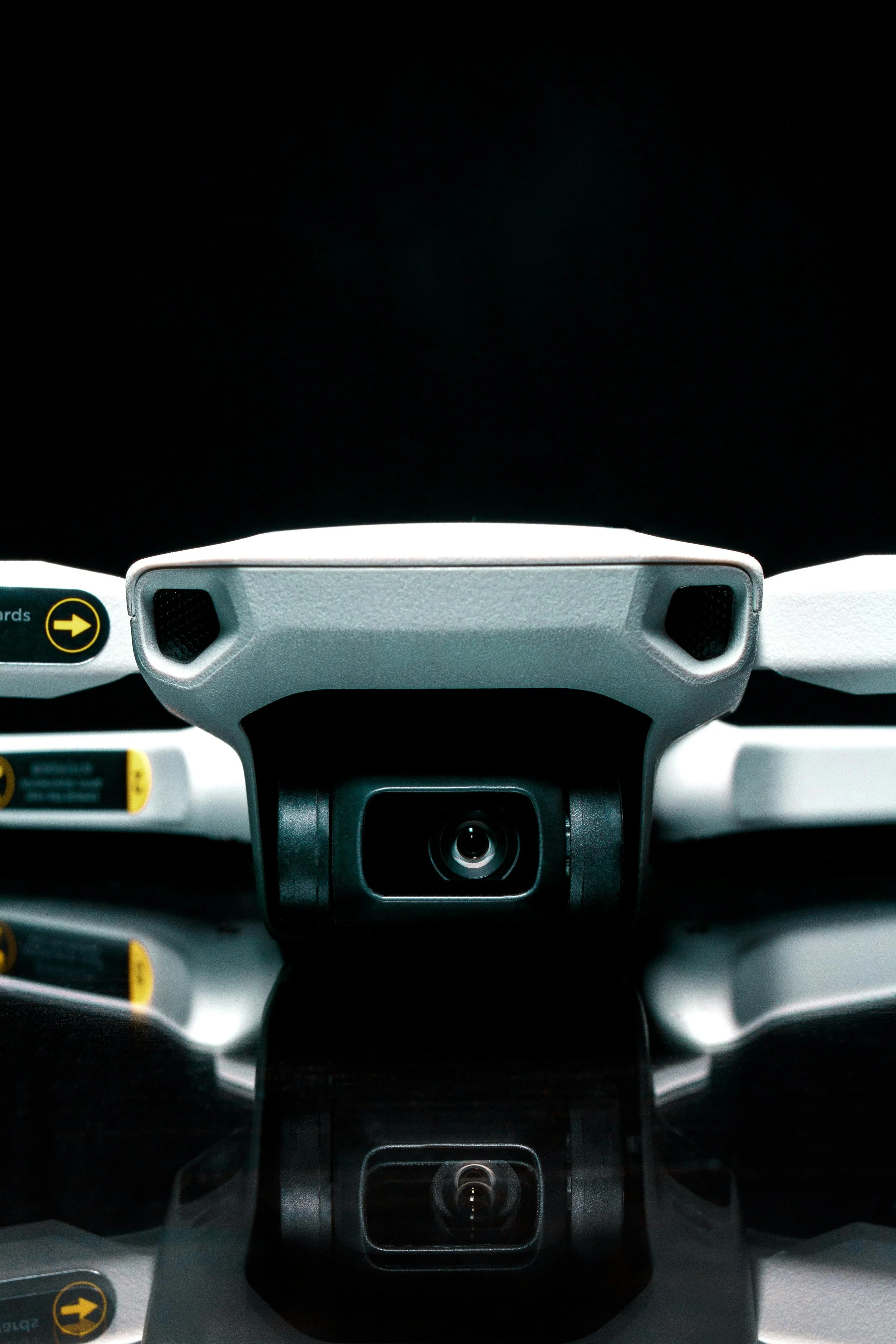 Close-up of a drone's camera and body with a black background.